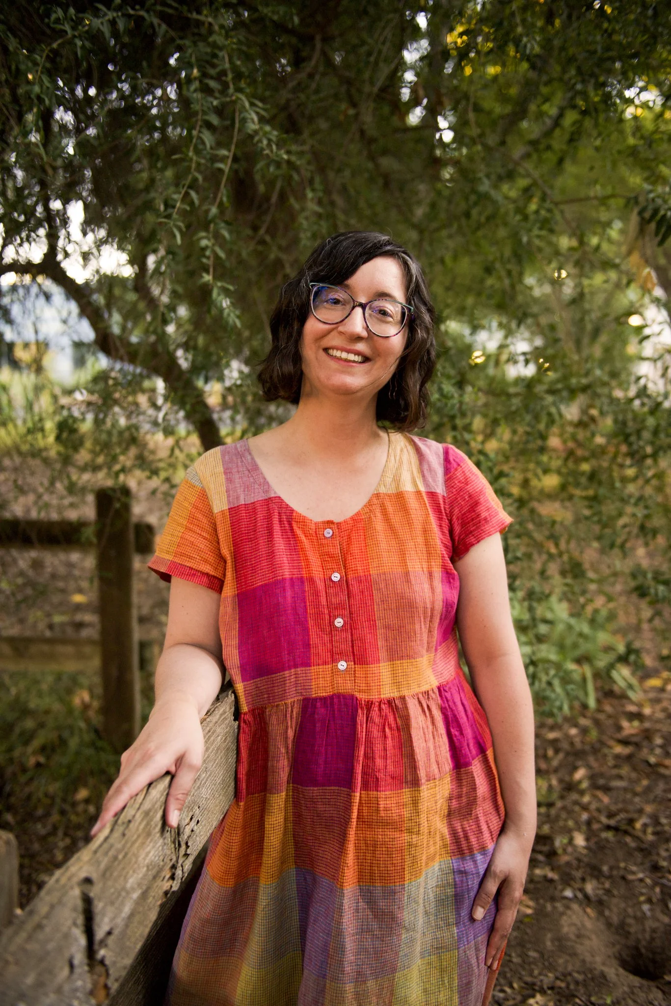 Rebecca Huval LCSW leans against a fence in the Sacramento State Arboretum. Rebecca Huval is a grief therapist and works with clients struggling with infertility, chronic illness, pet loss and other types of disenfranchised grief.