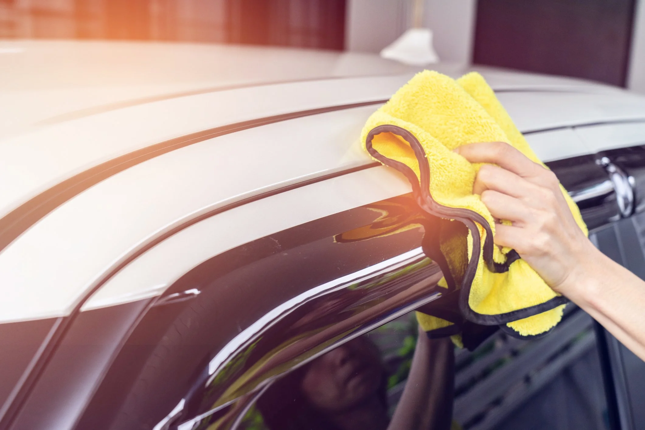 yellow microfibre cloth wiping shinny car