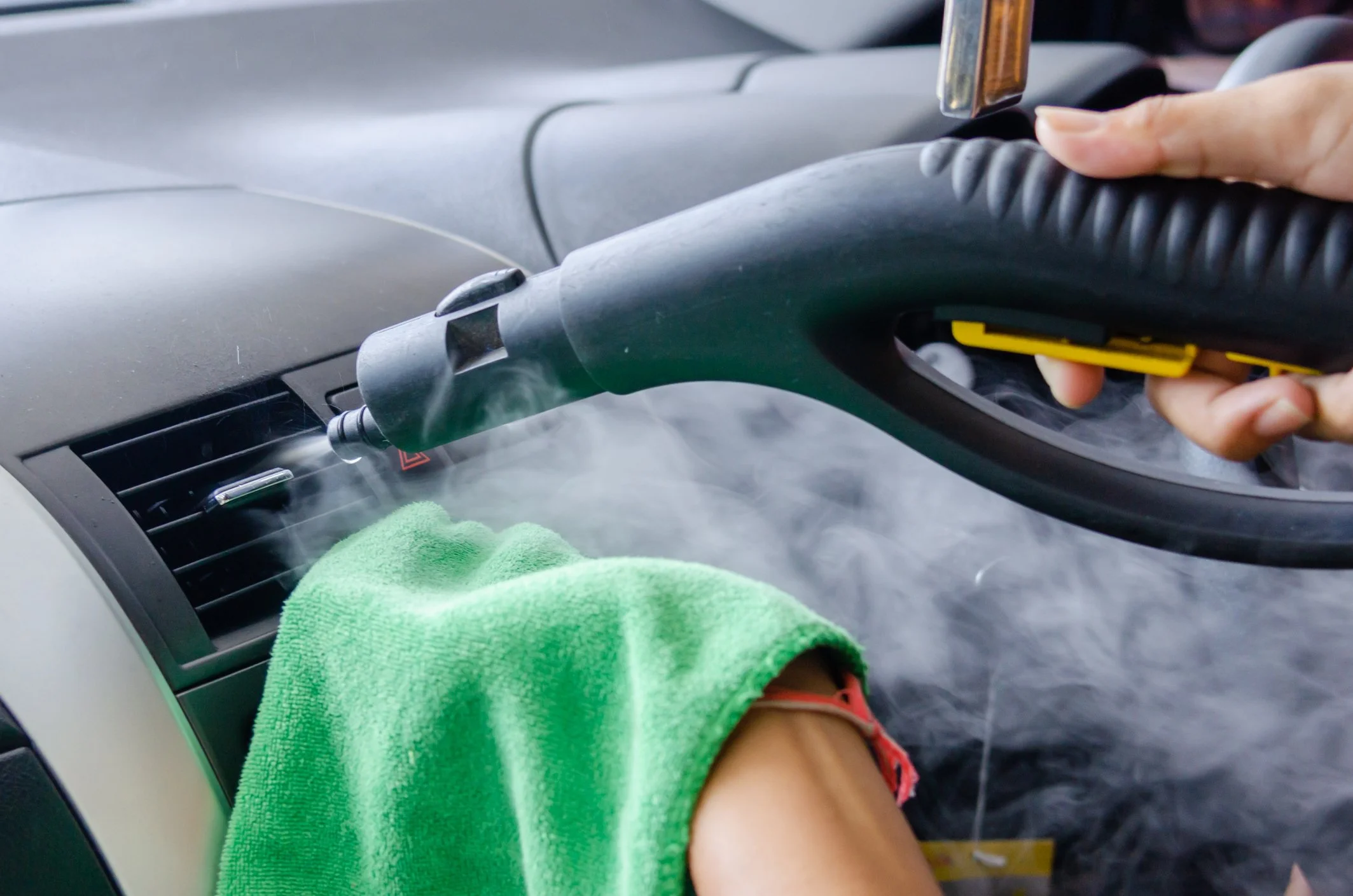 steam cleaning car air vents with green cloth