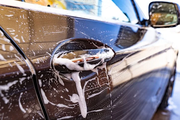 black car handle with soap suds