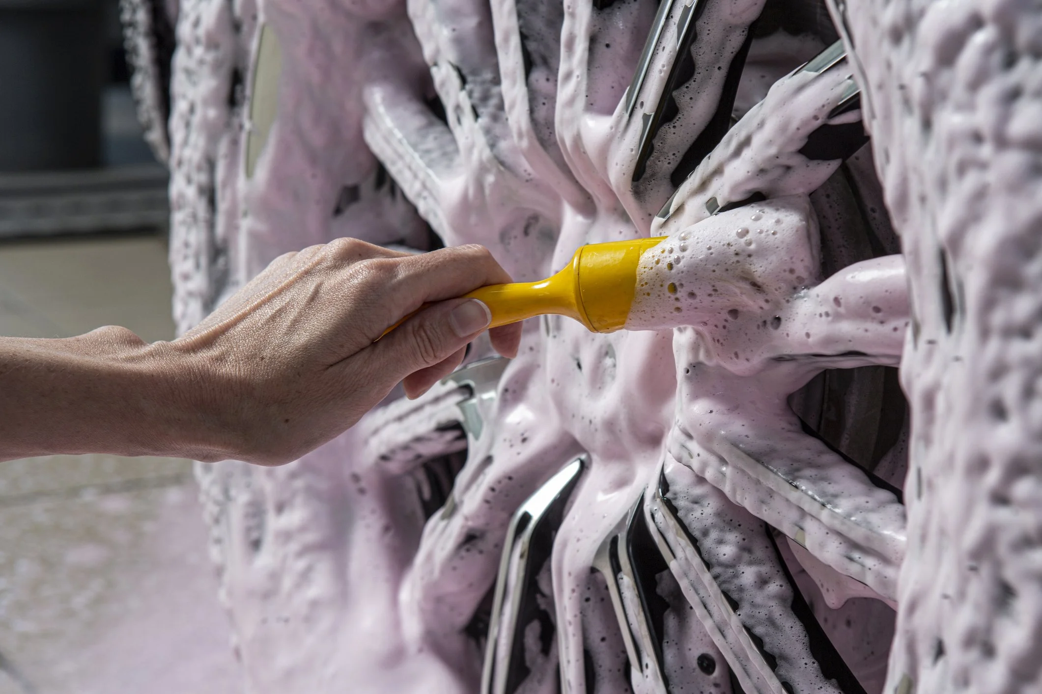 a car wheel being cleaned using foam