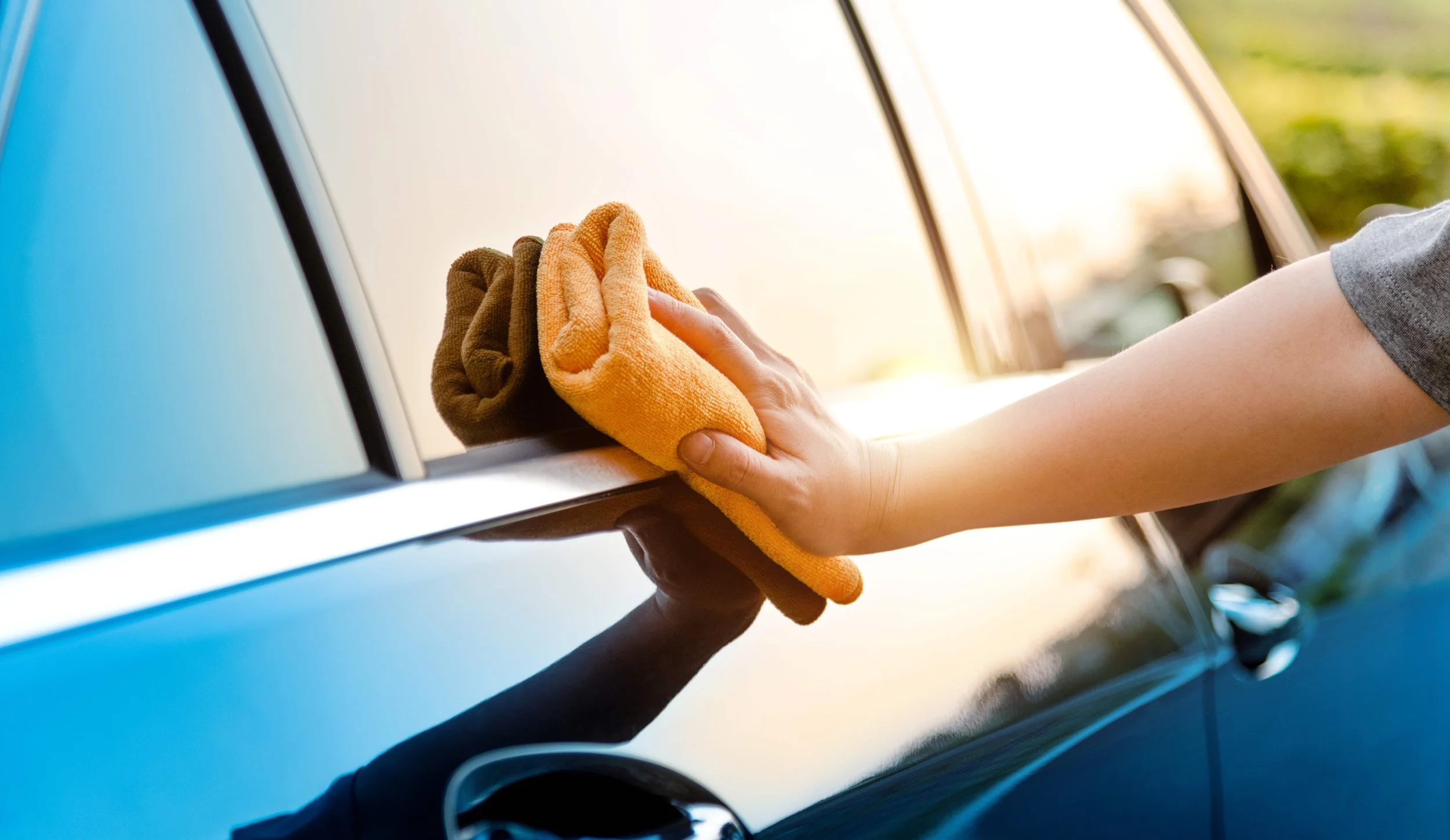 orange microfibre cloth wiping a car