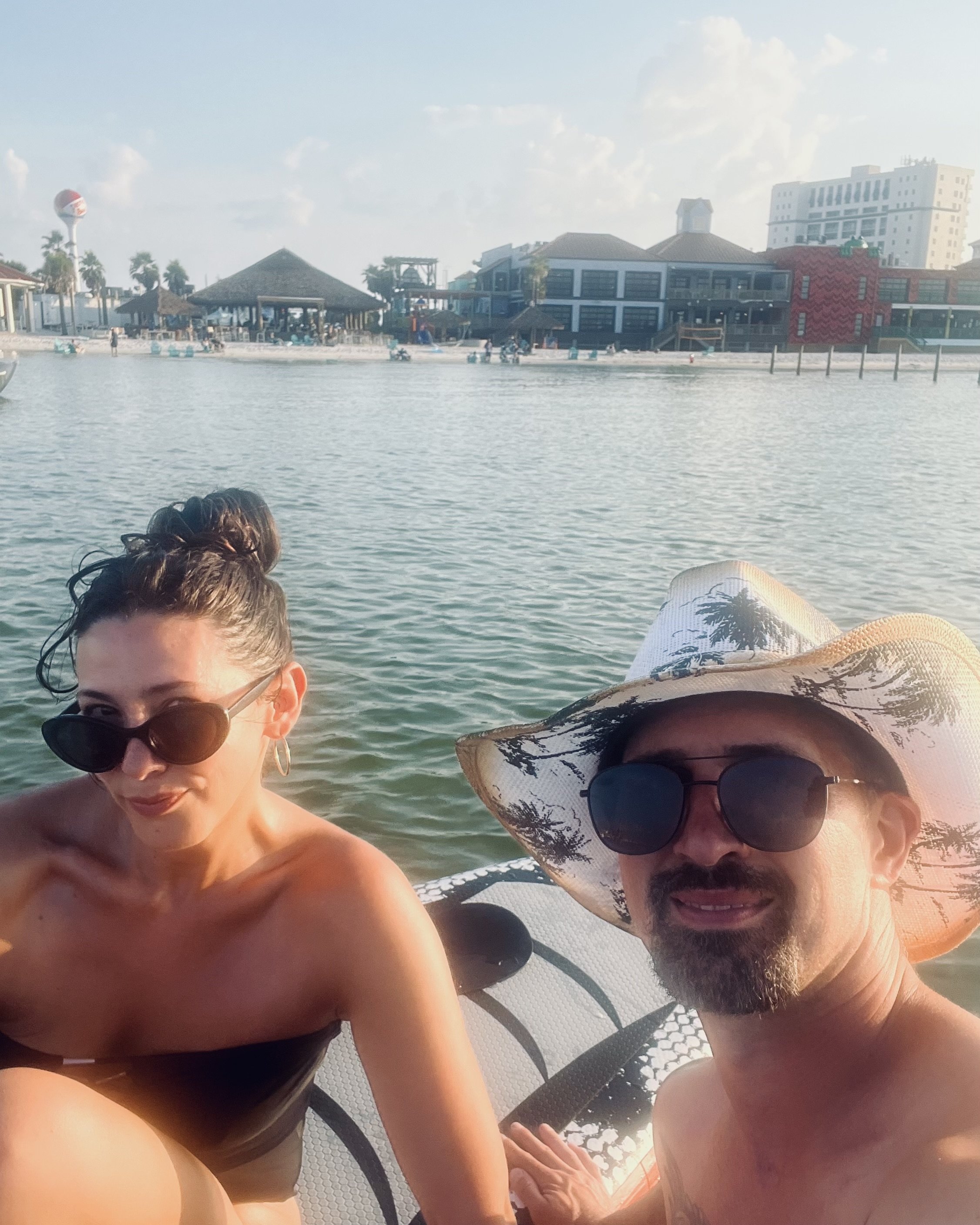 Two people enjoying a day at the beach paddle boarding