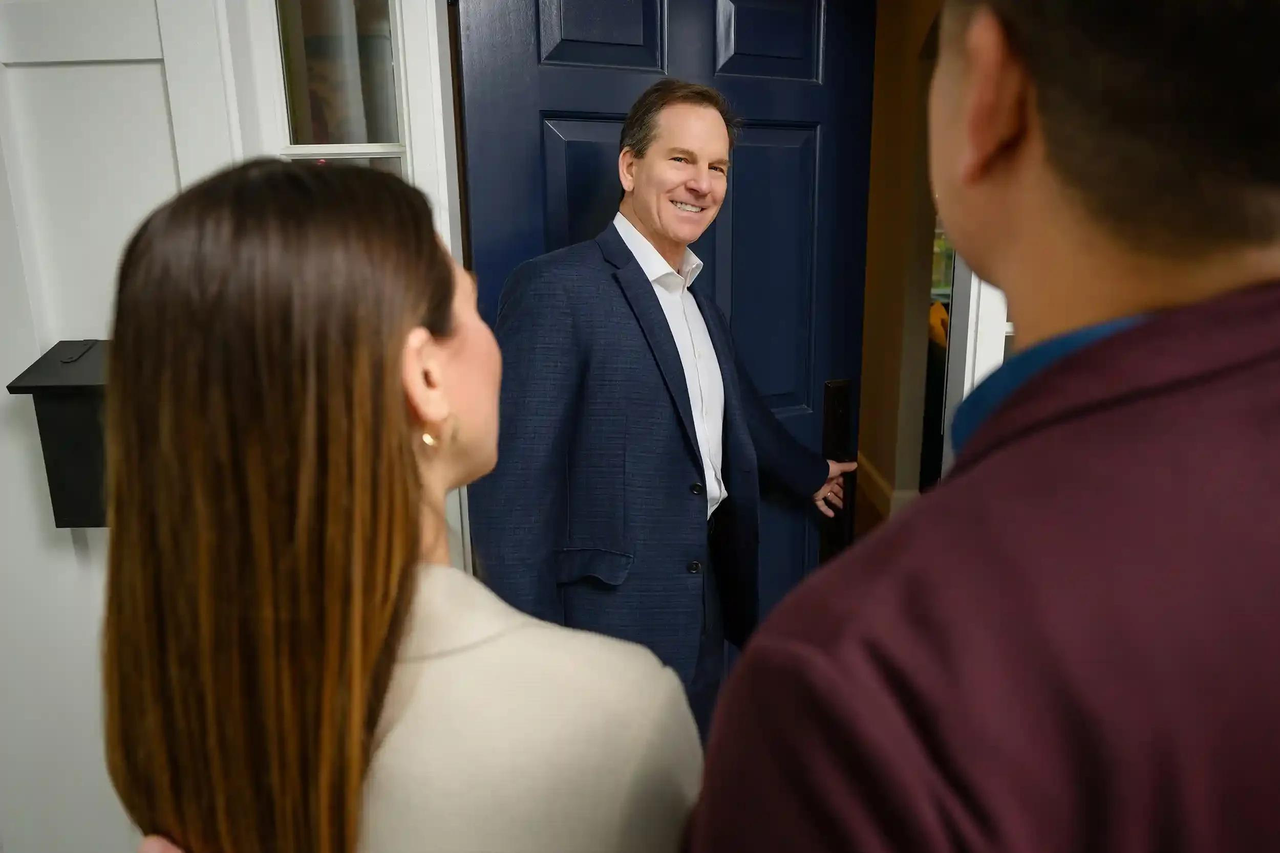 Jeff Beall showing a house opening the front door for clients
