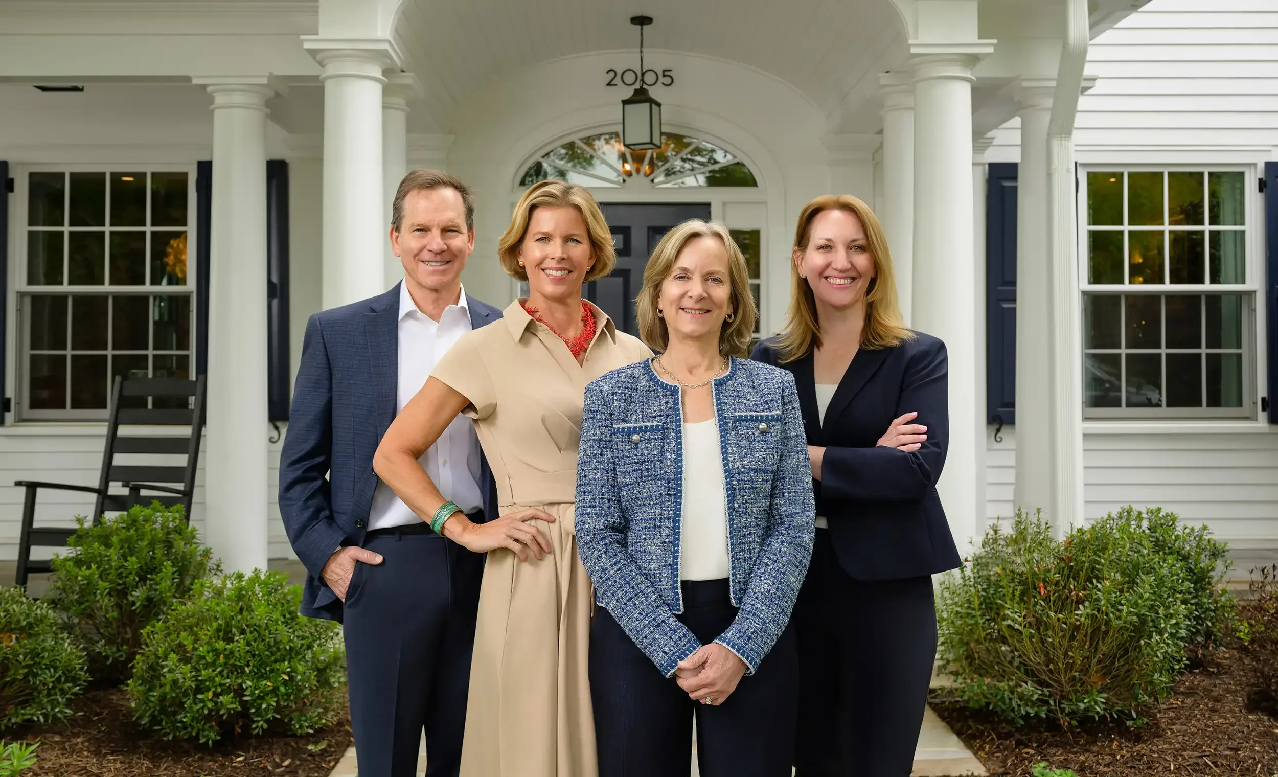 the Beall & Rehill team standing in front of modern colonial style home in North Arlington, Virginia