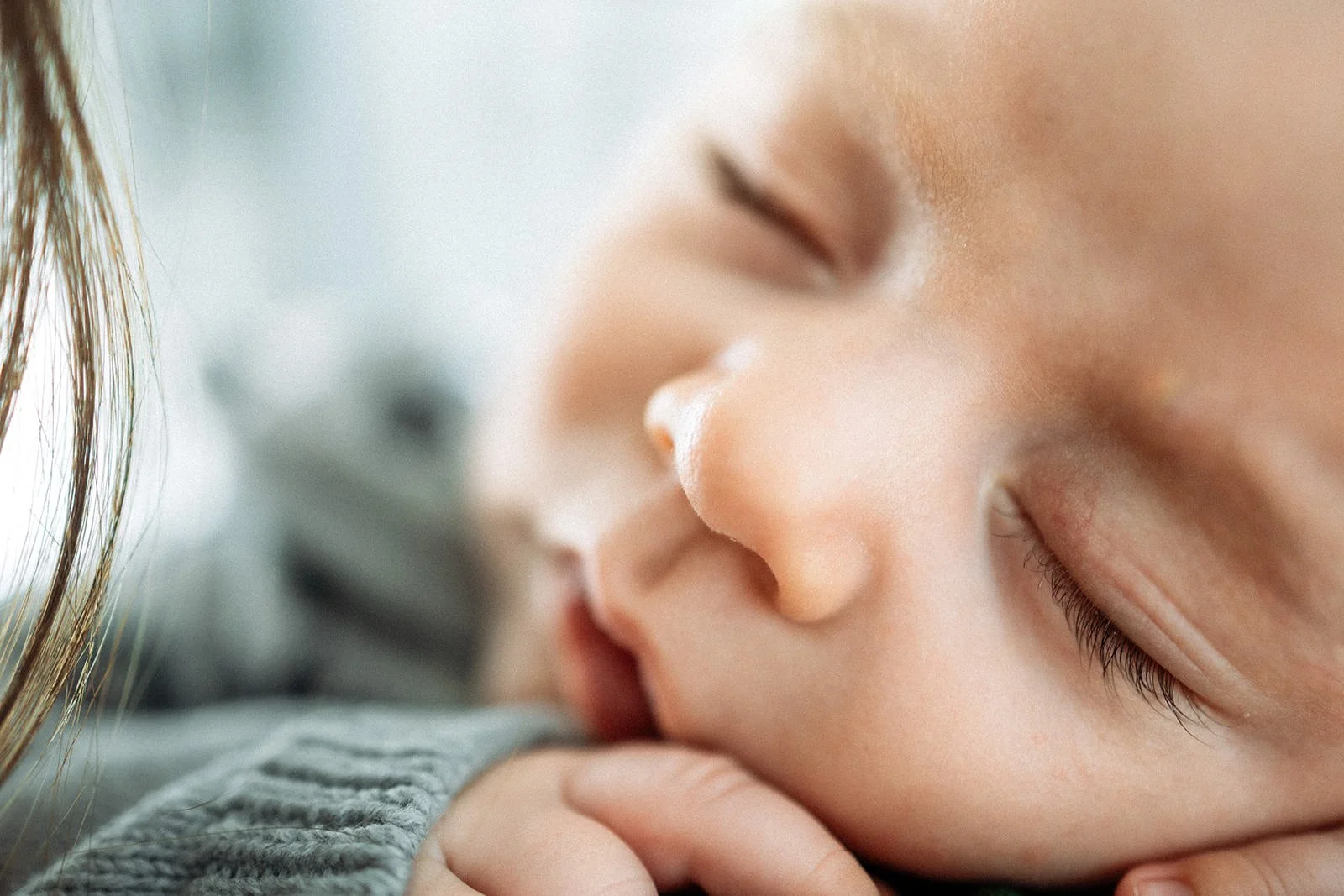 Close-up of a sleeping baby with closed eyes and a gentle expression.