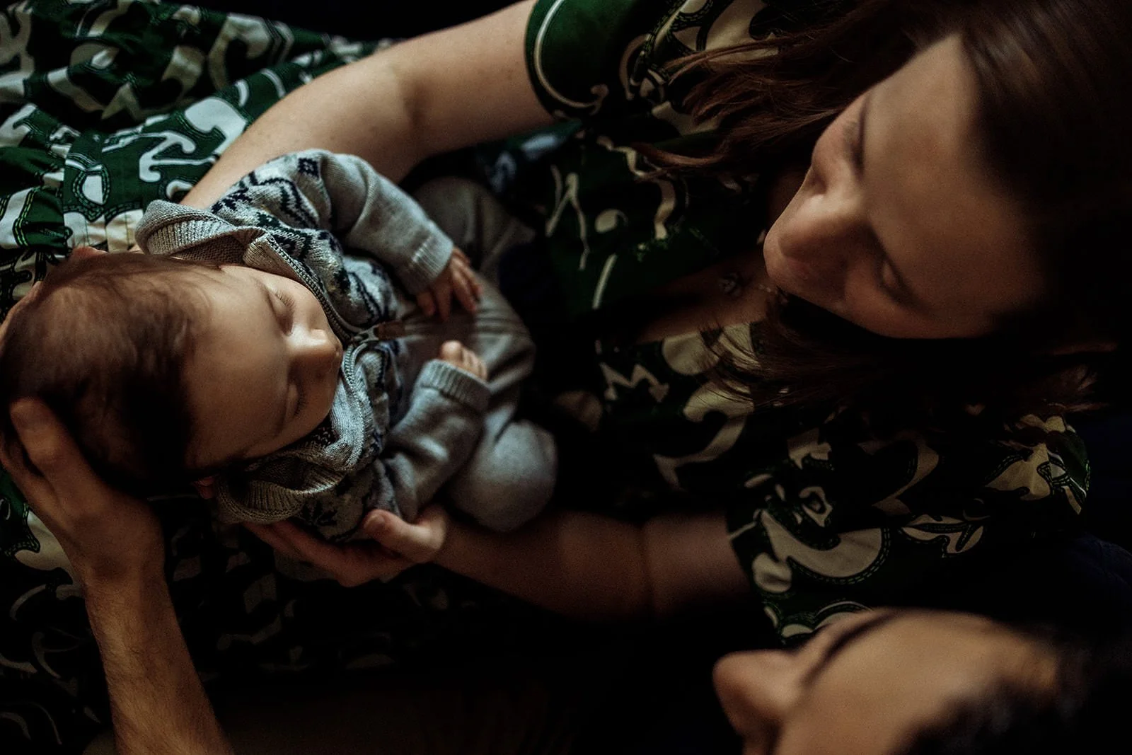 A woman cradling a sleeping baby in her arms.