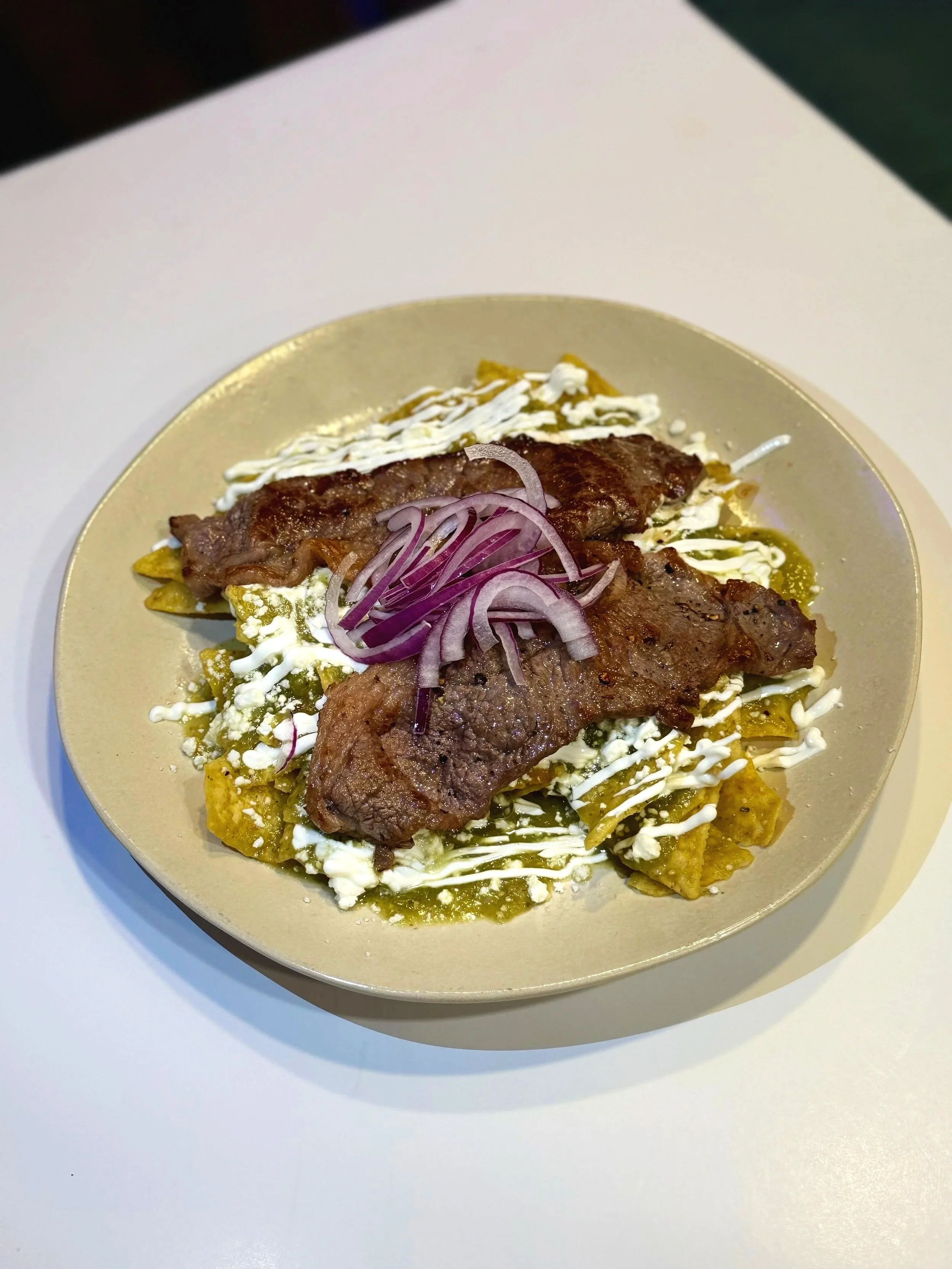 Chilaquiles Verdes topped with Carne Asada