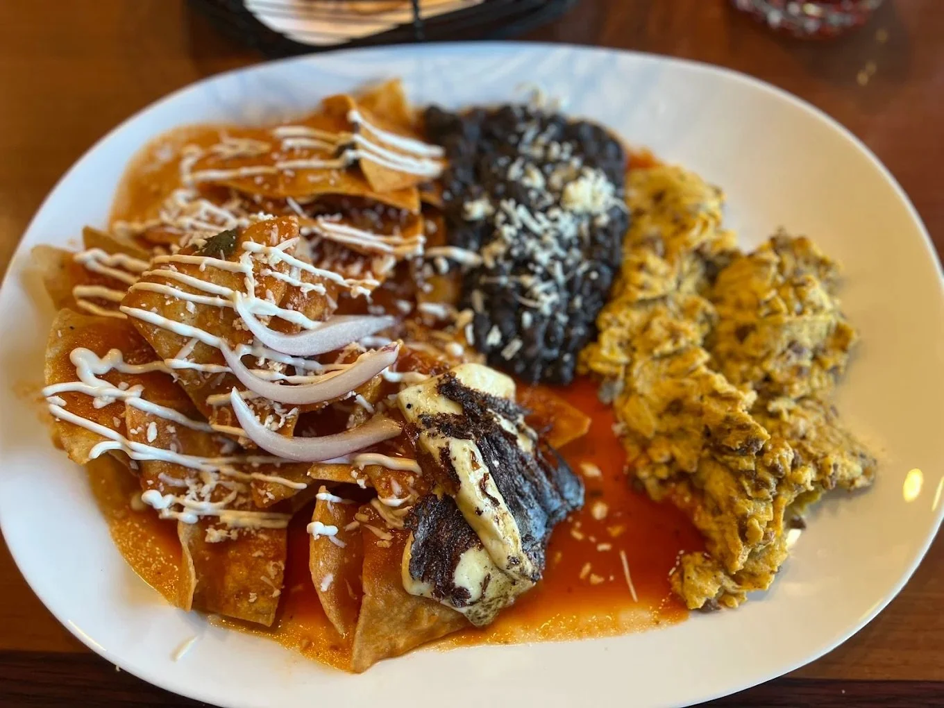 Plate of assorted Mexican food including nachos with cheese, black beans, and rice.
