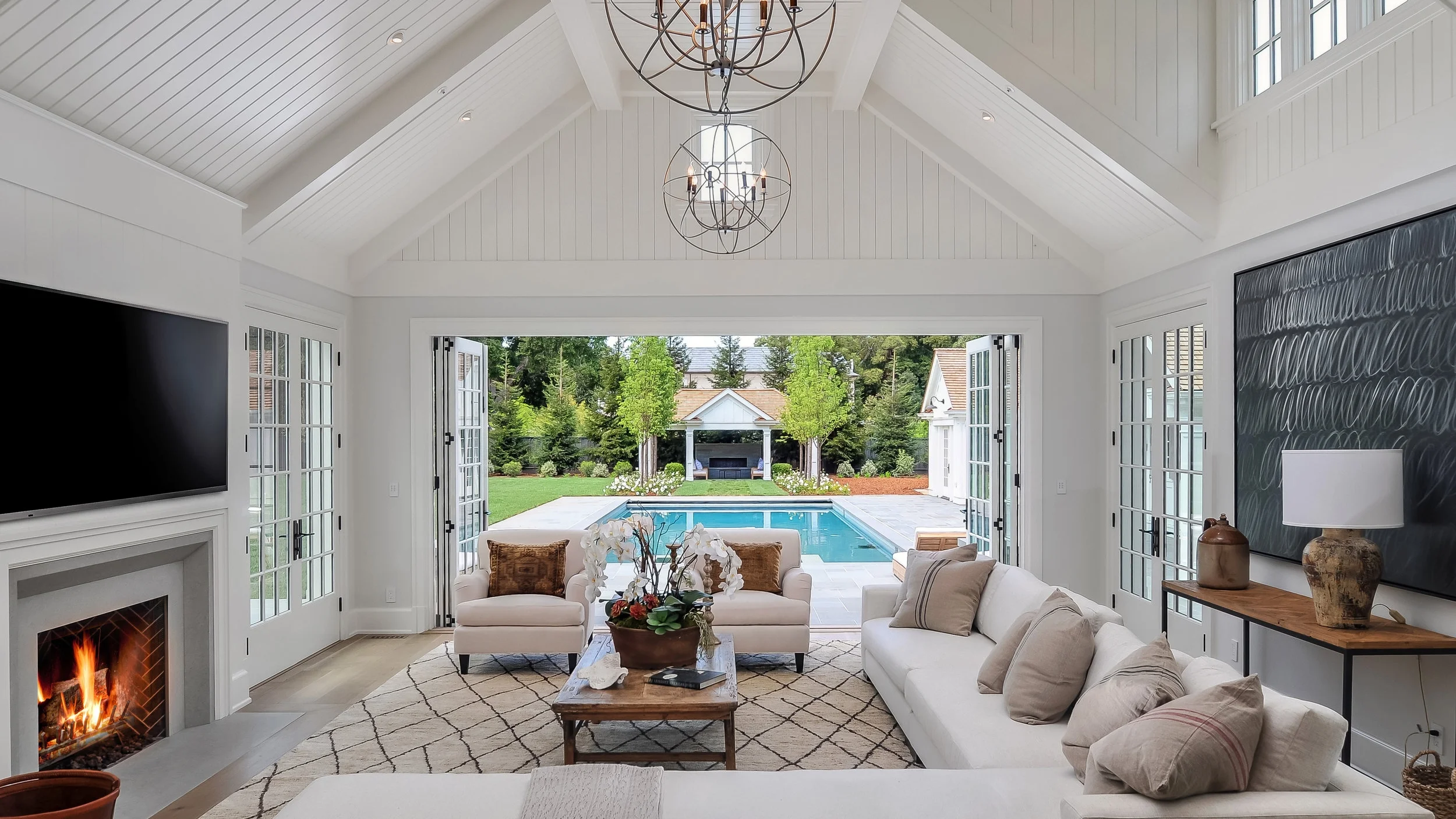 Open family room with fireplace and bi-fold, French doors.