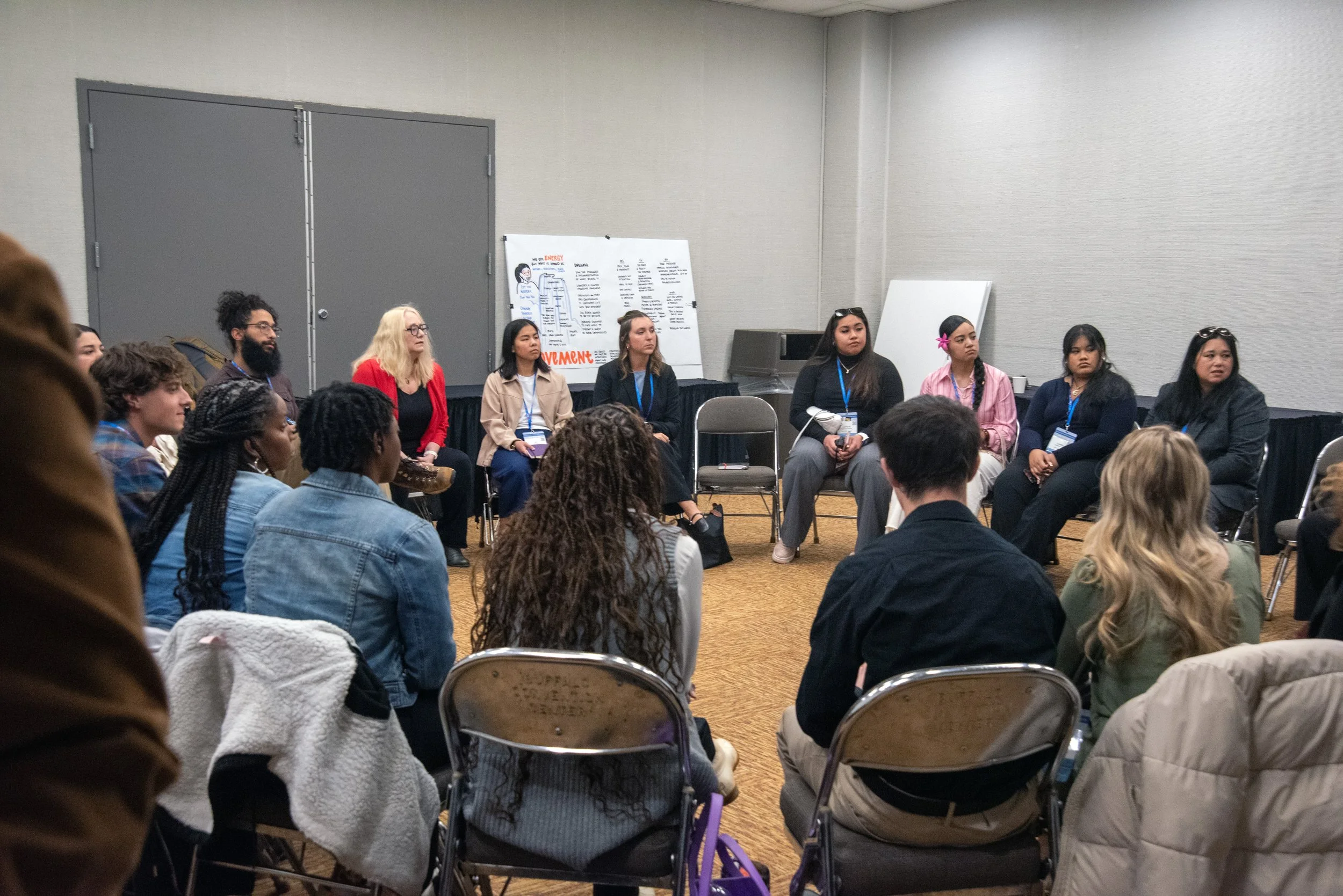 Participants seated in a group discussion during a workshop or leadership session, sharing ideas and engaging in collaborative learning.