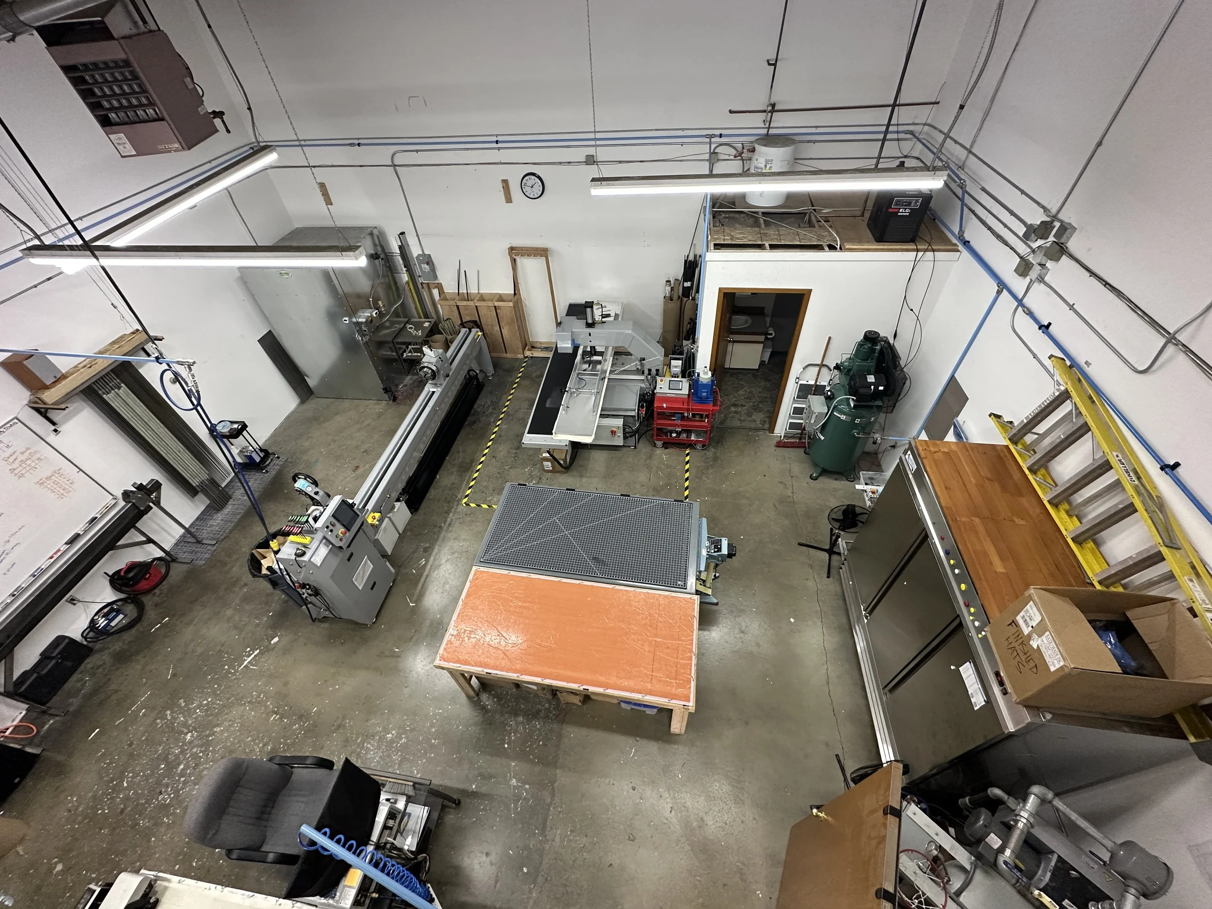 Key equipment shown: freezer, air compressor, rolling table, tape wrapper, oven