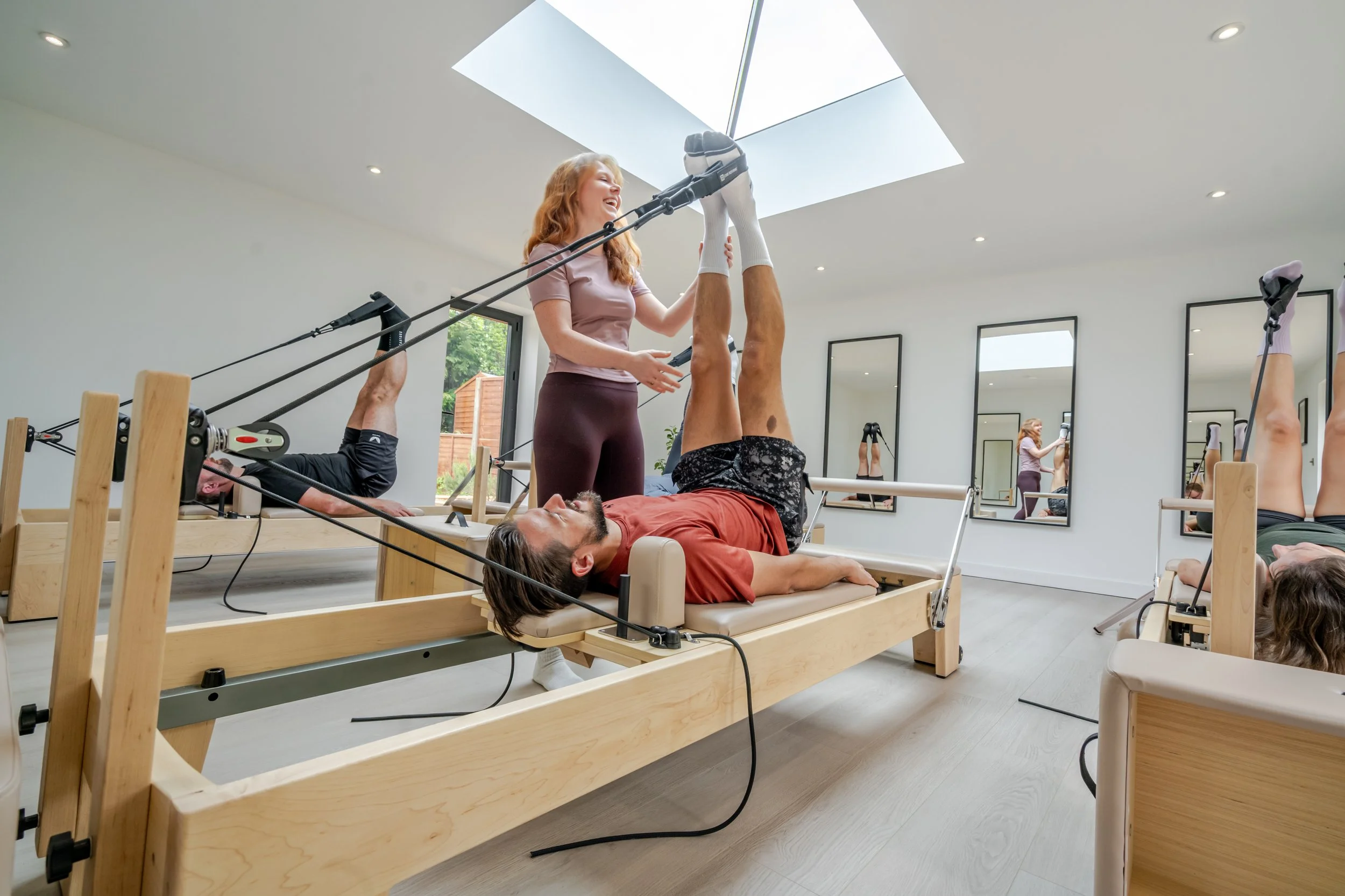 Small group reformer Pilates class at Reform With Marina studio in Overton.