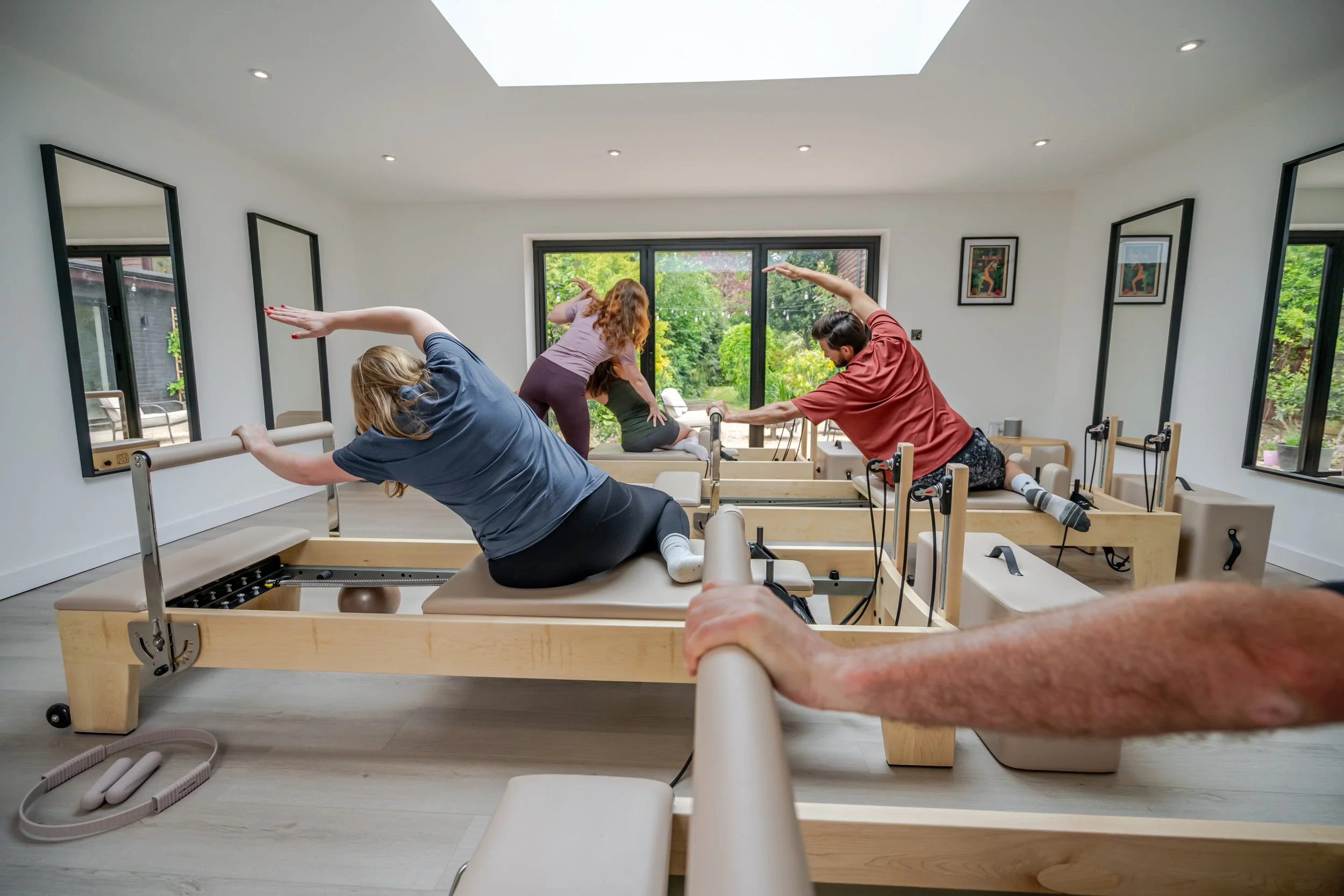 Small group reformer Pilates class in a calm and spacious studio environment.