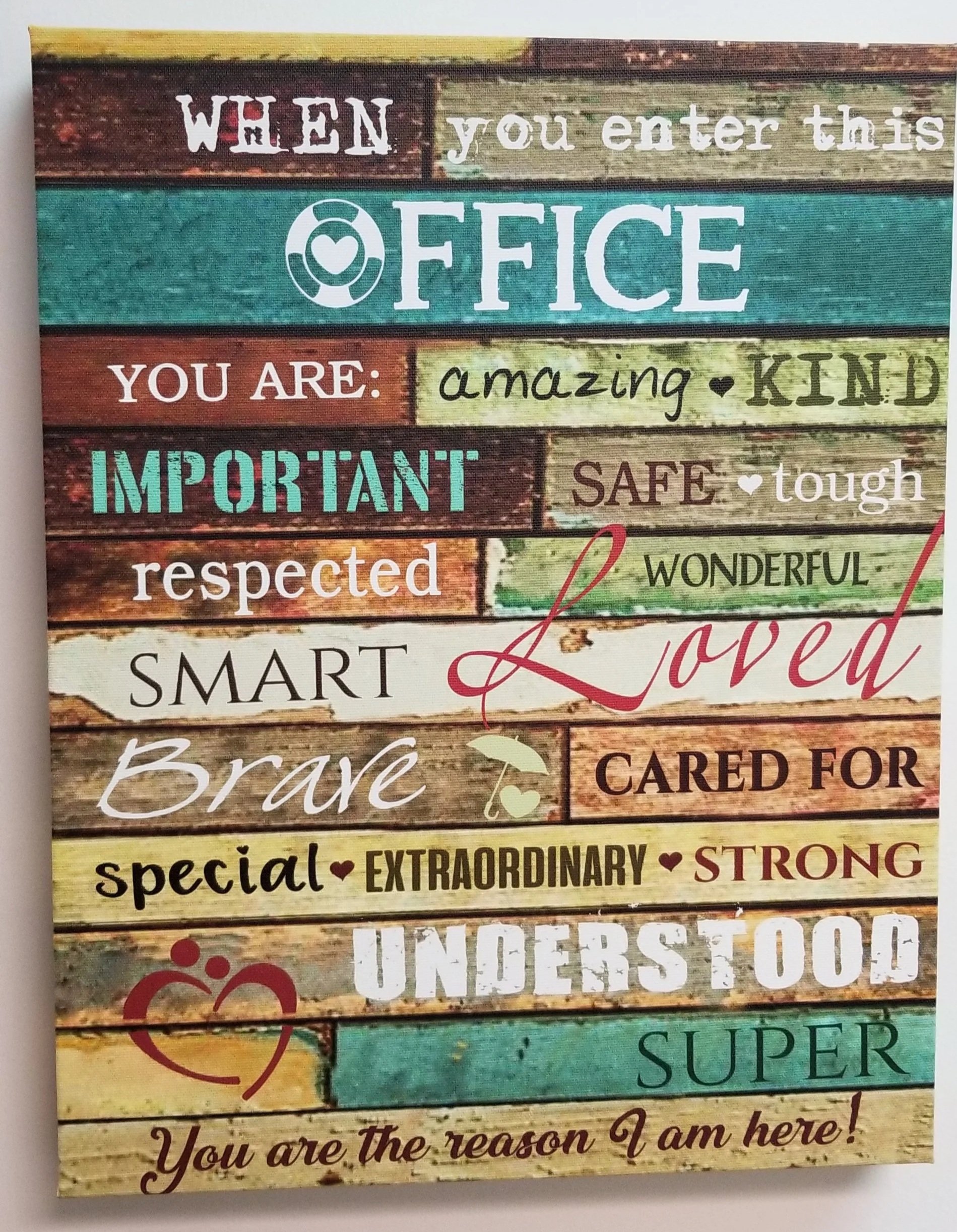 Decorative sign with colorful panels and various inspirational words and phrases, including 'When you enter this office,' 'you are: amazing, kind, important, safe, respected, brave, loved, special, extraordinary, strong, underdog, super.'