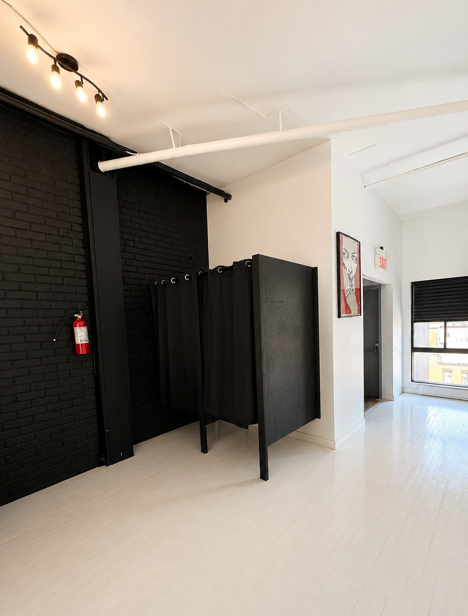 Photo of a small dressing room with black curtains.