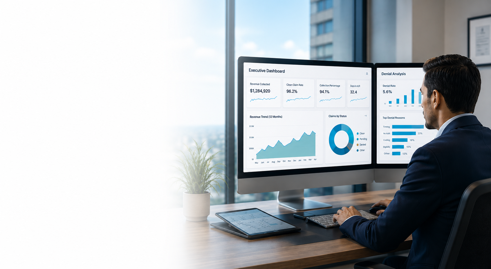 Businessman in a suit working at a desk with dual monitors displaying dashboards and charts in a modern office.