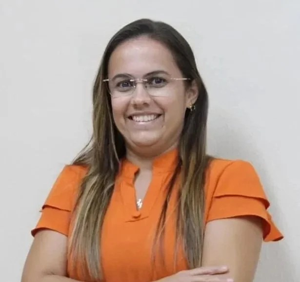 Mulher sorridente com óculos, vestido laranja, fundo branco