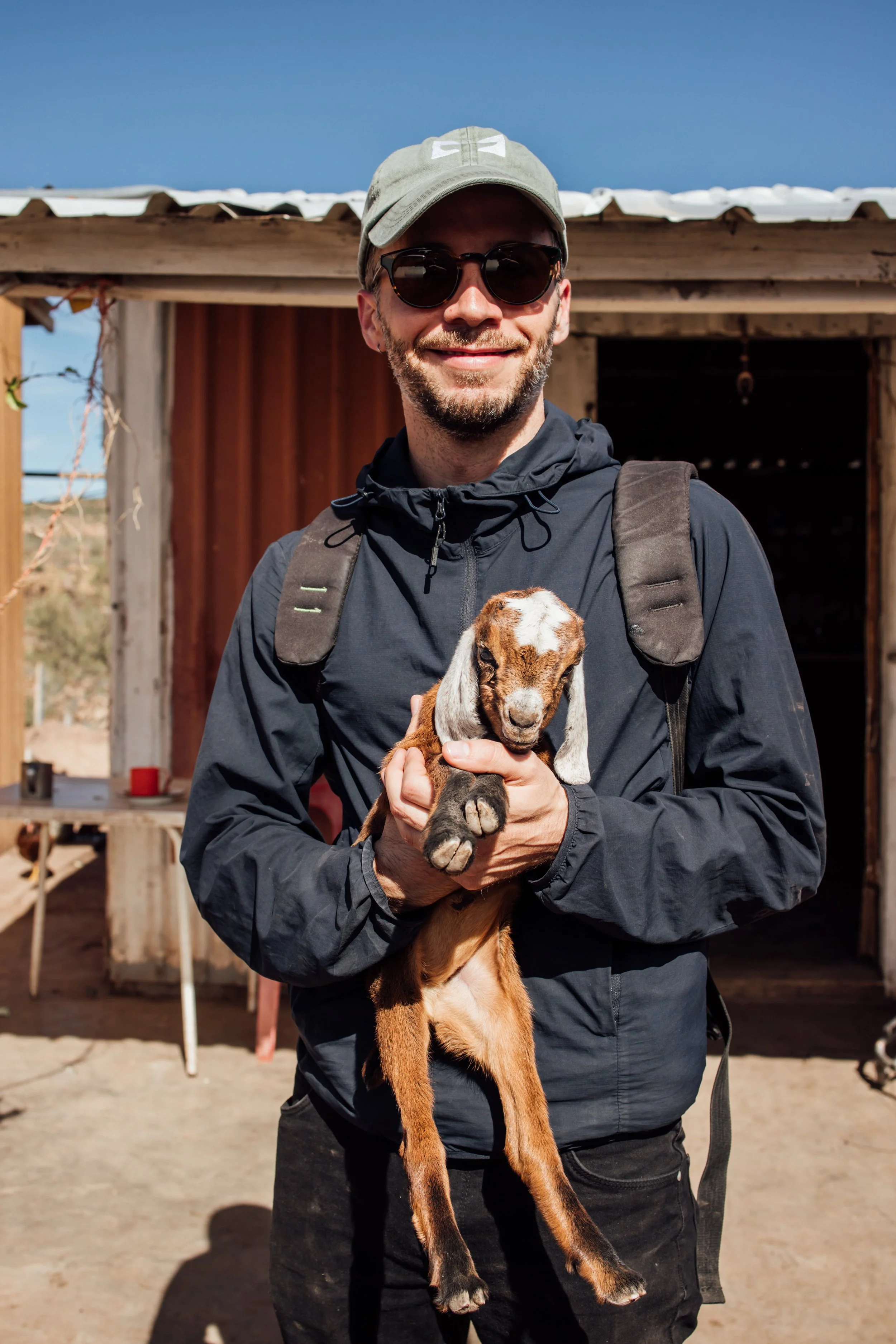 Visitante sosteniendo un cabrito en San Francisco de la Sierra, Mulegé, Baja California Sur.