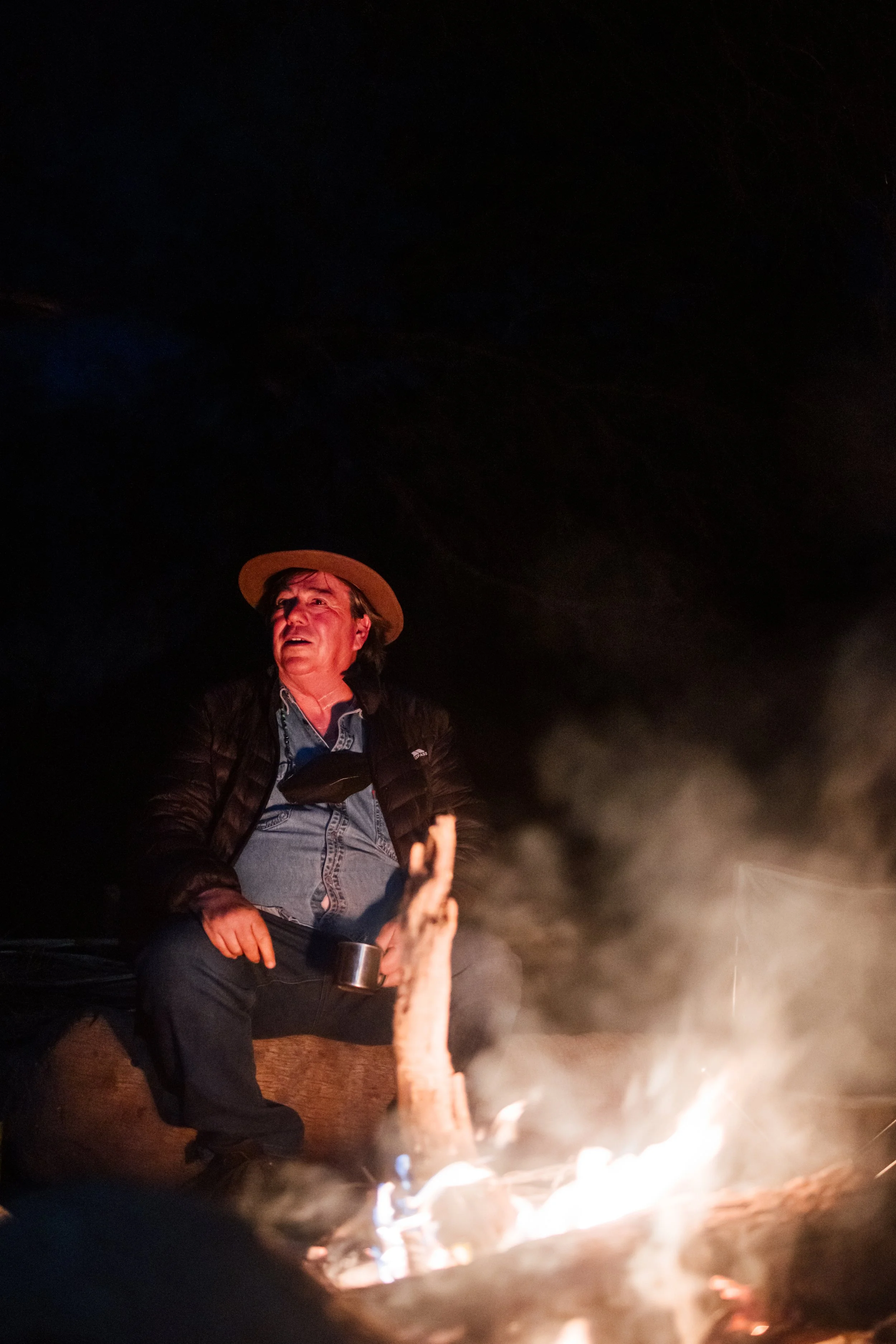 Guía junto a una fogata durante actividad nocturna en la Sierra de San Francisco, Mulegé, Baja California Sur.