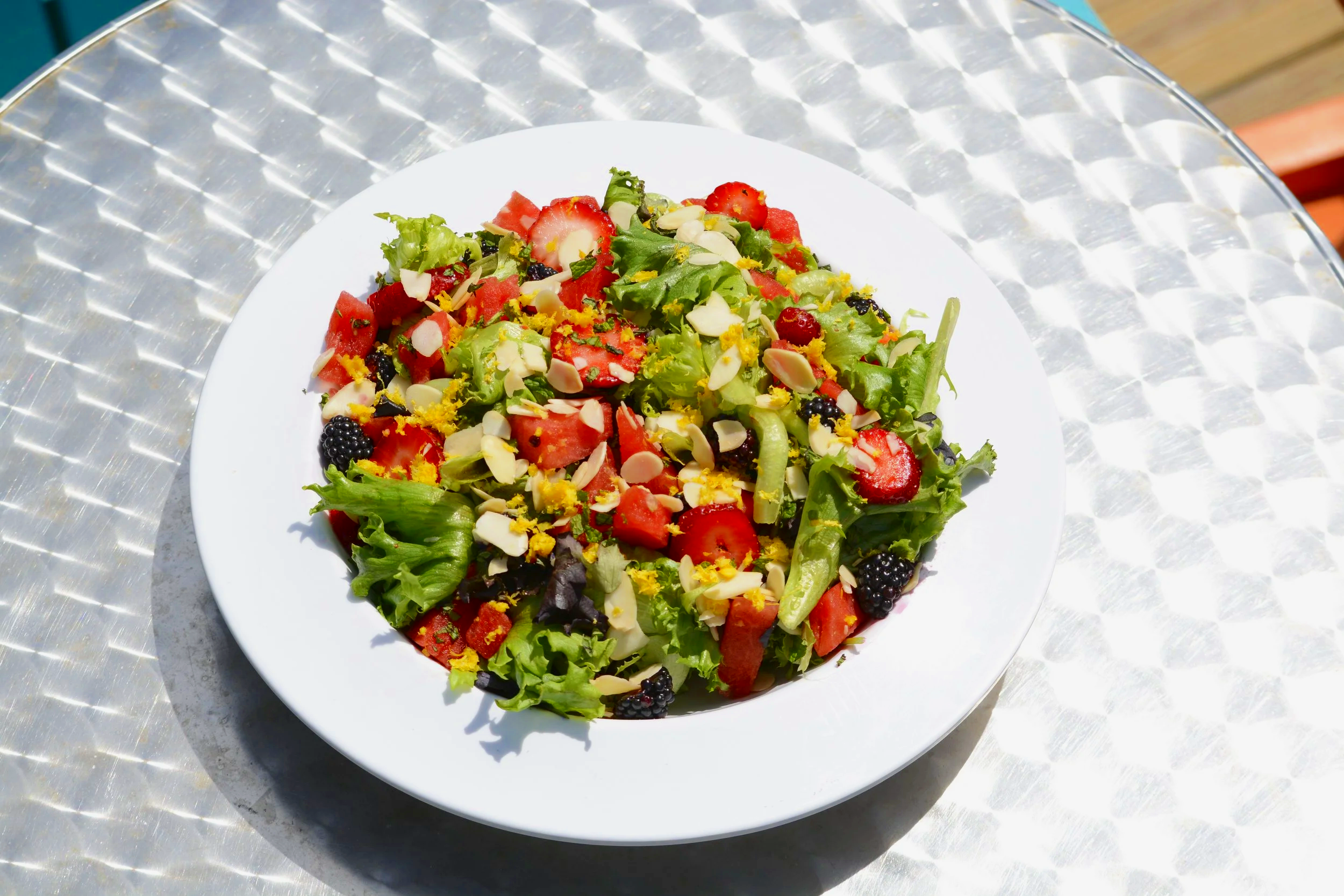The Summer Wave- a refreshing salad with fresh fruit, lemon zest, and balsamic vinaigrette on a bed of mixed greens.