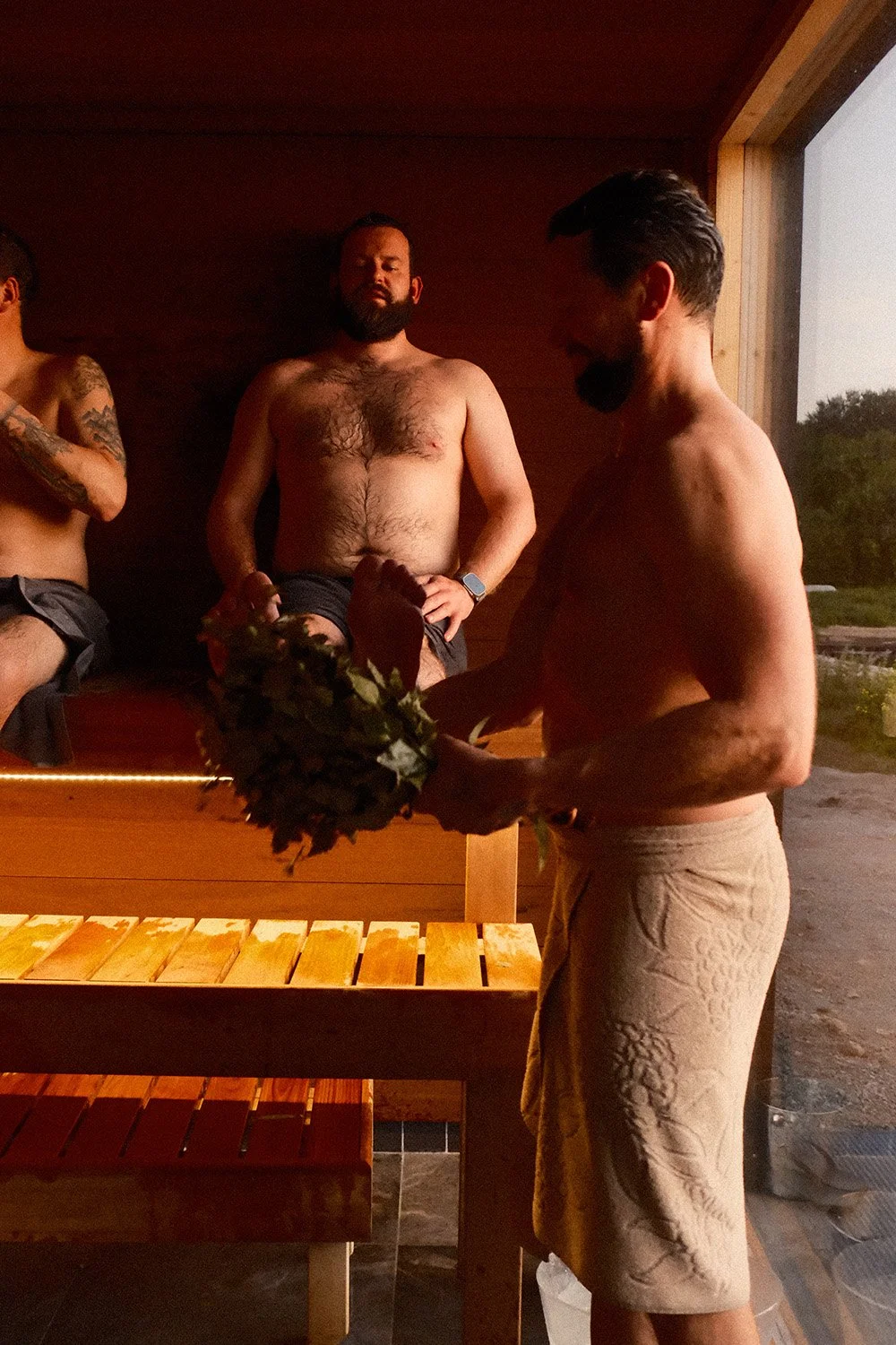 Seltskond nautimas saunarituaali ja vihtlemist.