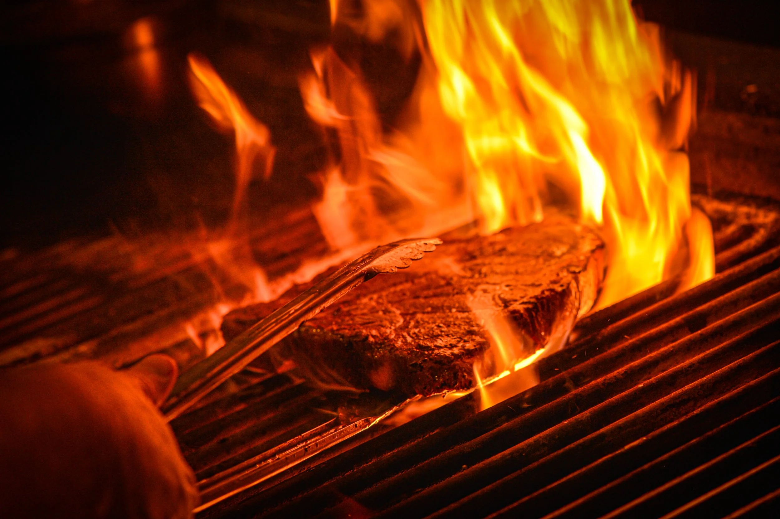 Close-up of burning logs with bright orange and yellow flames.
