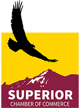Silhouette of a bird flying above a yellow background with a mountain and purple banner that says 'Superior Chamber of Commerce'.