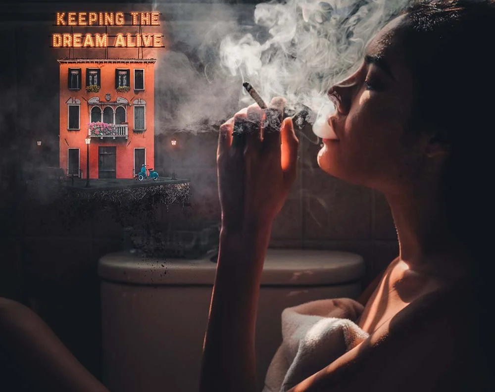 A woman smoking a cigarette with smoke curling up near her face, and a digitally added background featuring a pink building with the text 'KEEPING THE DREAM ALIVE' in neon lights, surrounded by dark clouds and city elements.