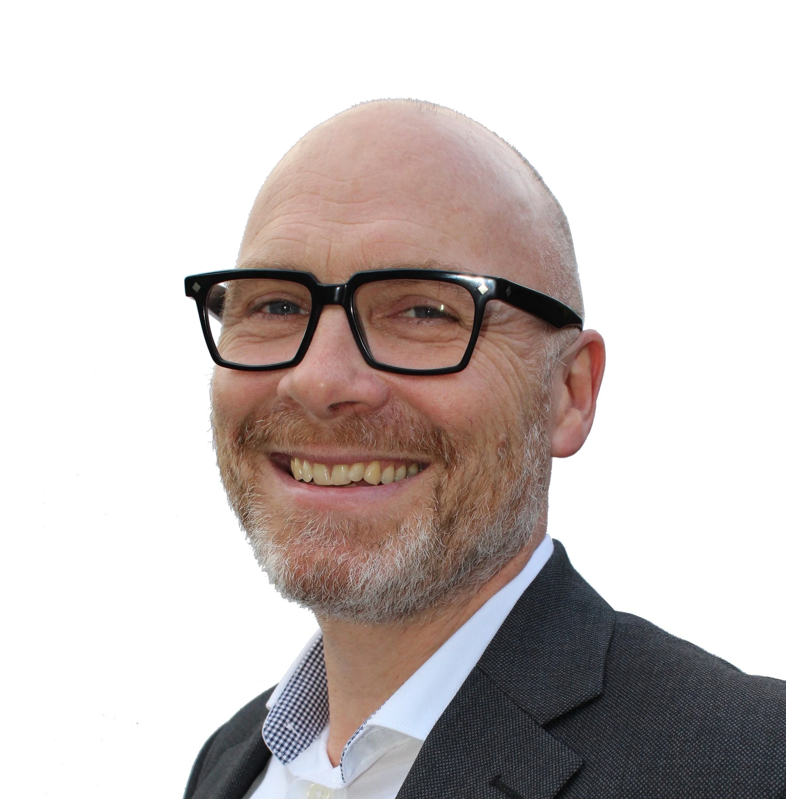 Close-up of a smiling man with glasses, a graying beard, dressed in a suit, white shirt, and checkered collar, with a bald head and light skin.