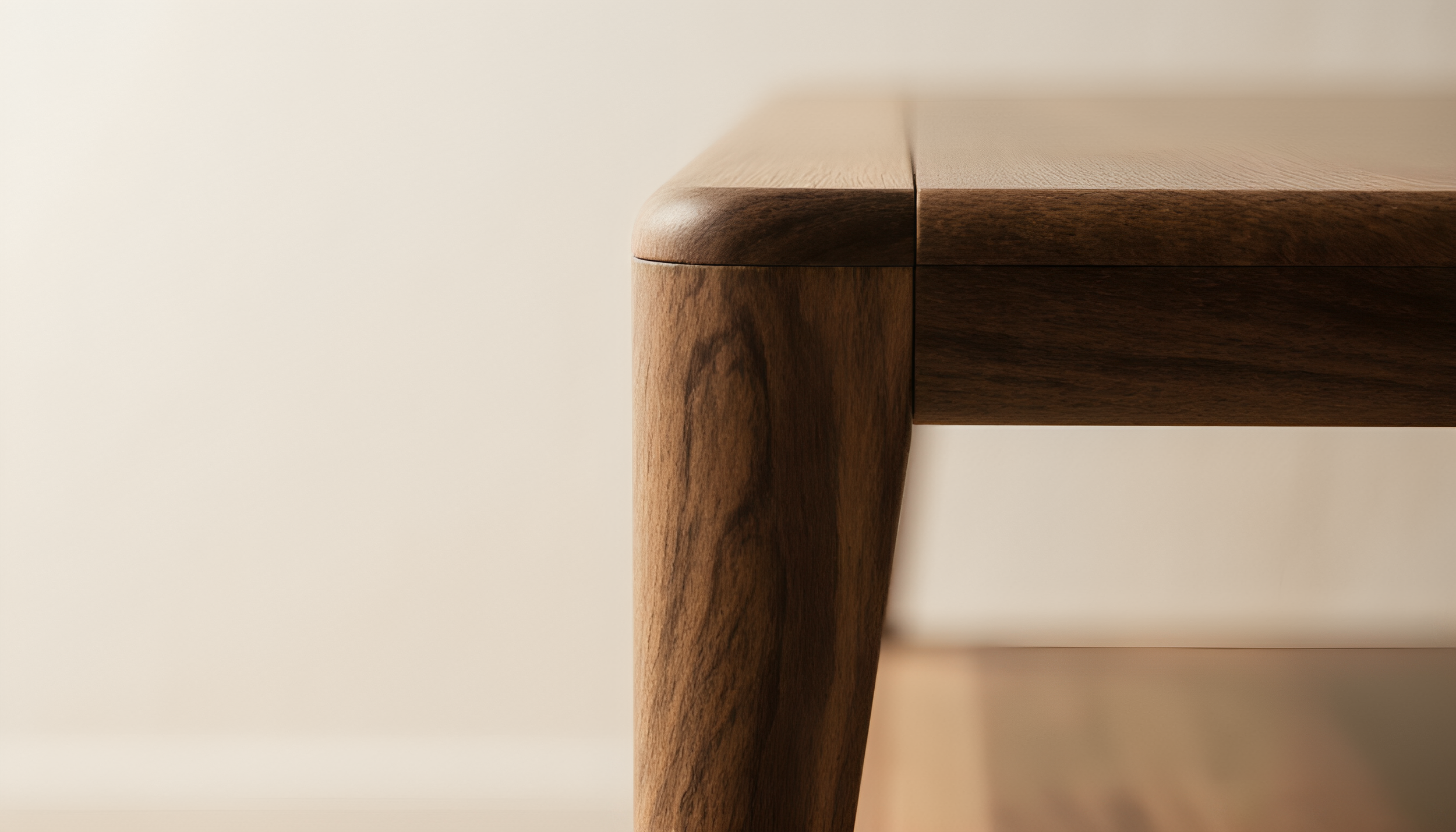 Close-up photo of a wooden table corner showing the edge and leg, with a smooth finish and natural wood grain, against a light, plain background.
