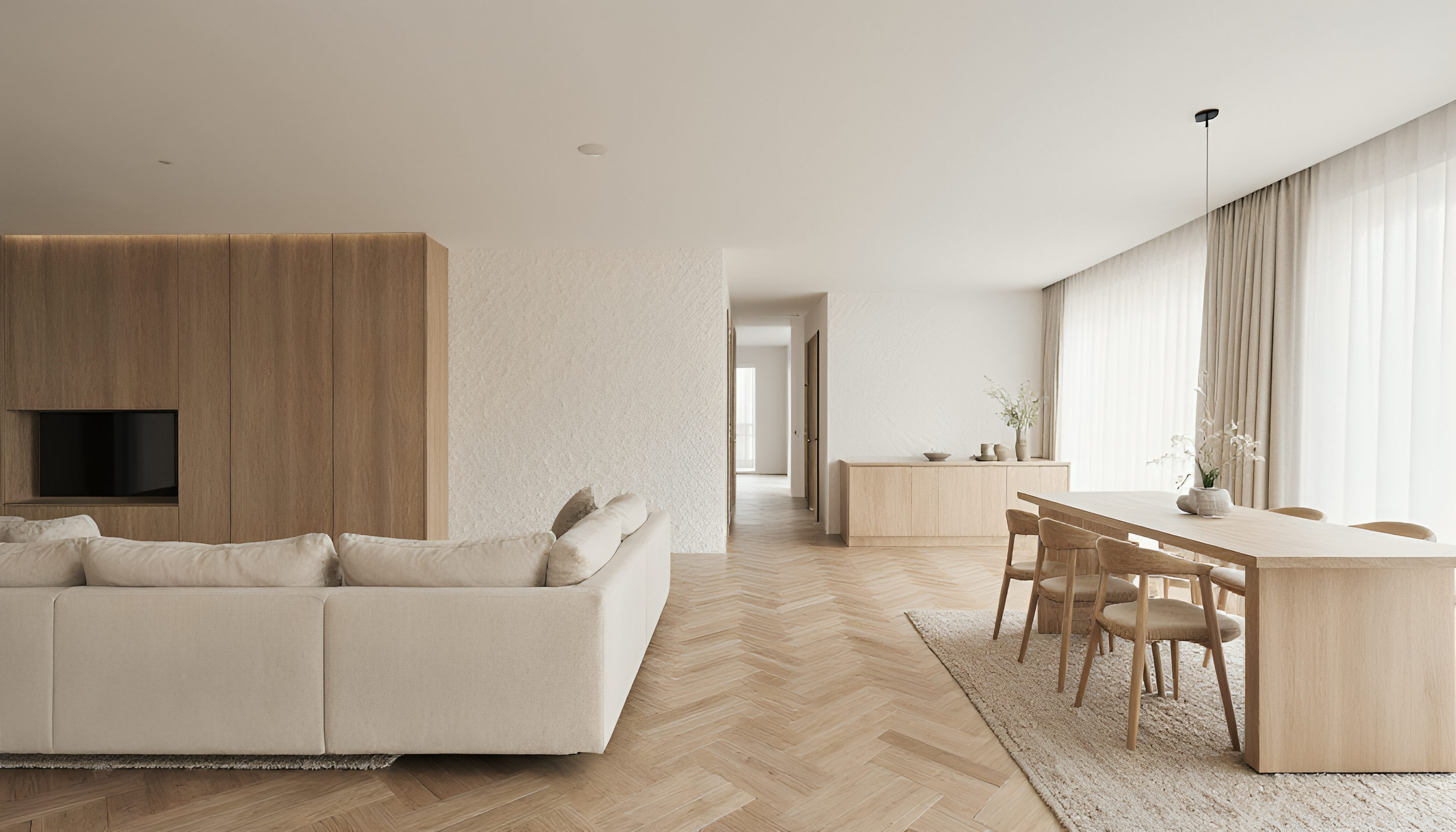 A modern, minimalist living room with a white sofa, wooden accent wall, dining table with chairs, and large windows with sheer curtains, decorated with vases and plants.