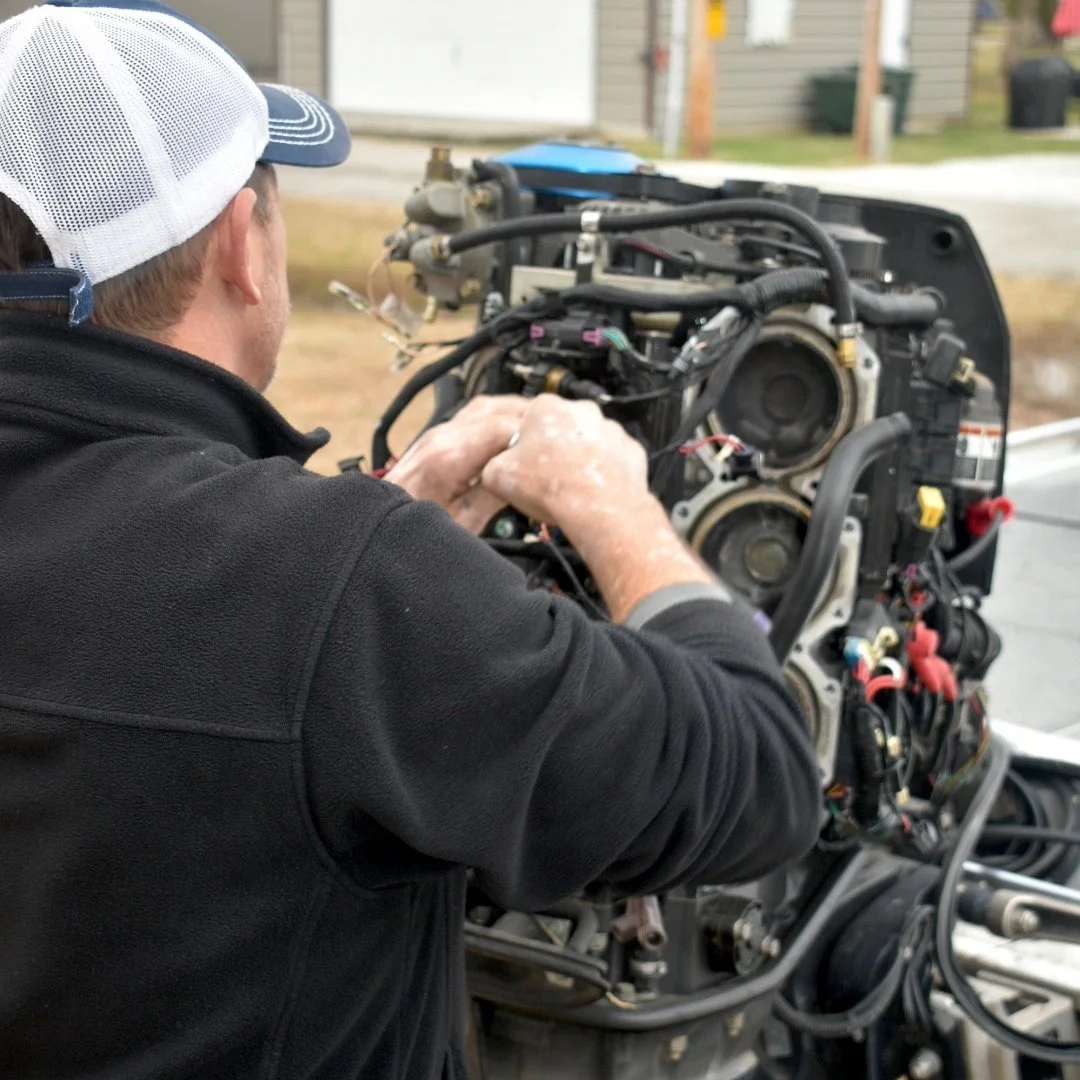 Marine technician working on an outboard boat motor during repair and diagnostic service at Gordon’s Xtreme Marine.