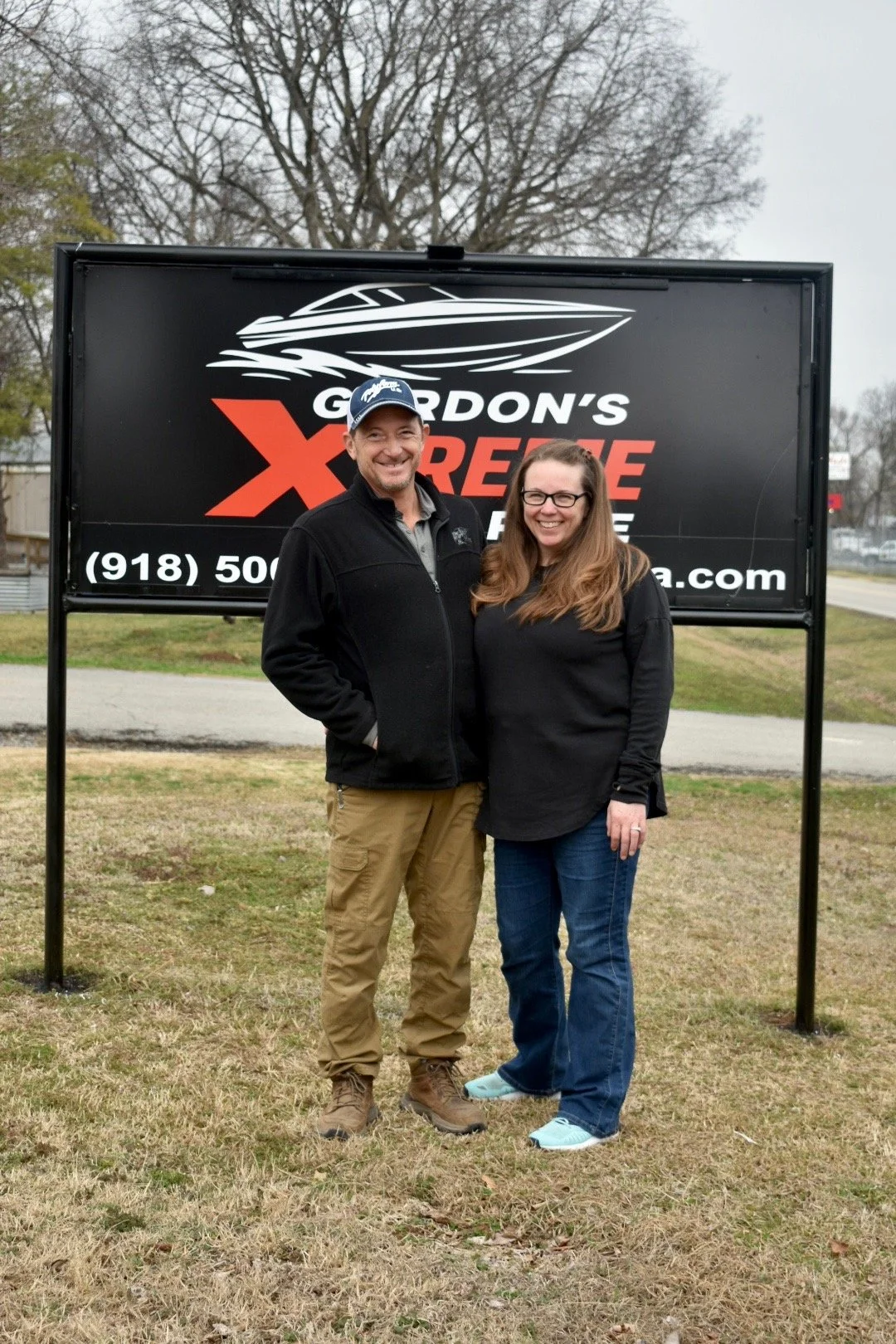 Owners of Gordon’s Xtreme Marine standing in front of the company sign in Grand Lake, Oklahoma.