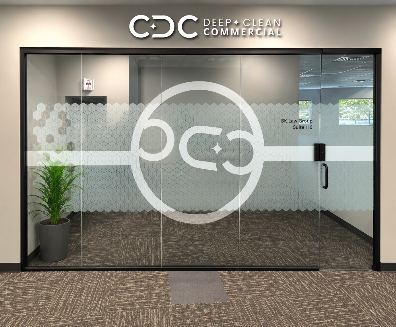 Entrada de oficina con cartel de logotipo y señal de privacidad en la parte superior, vista a través de puertas de vidrio con logotipo de Deep Clean Commercial y texto de oficina BK Law Group en la esquina derecha.