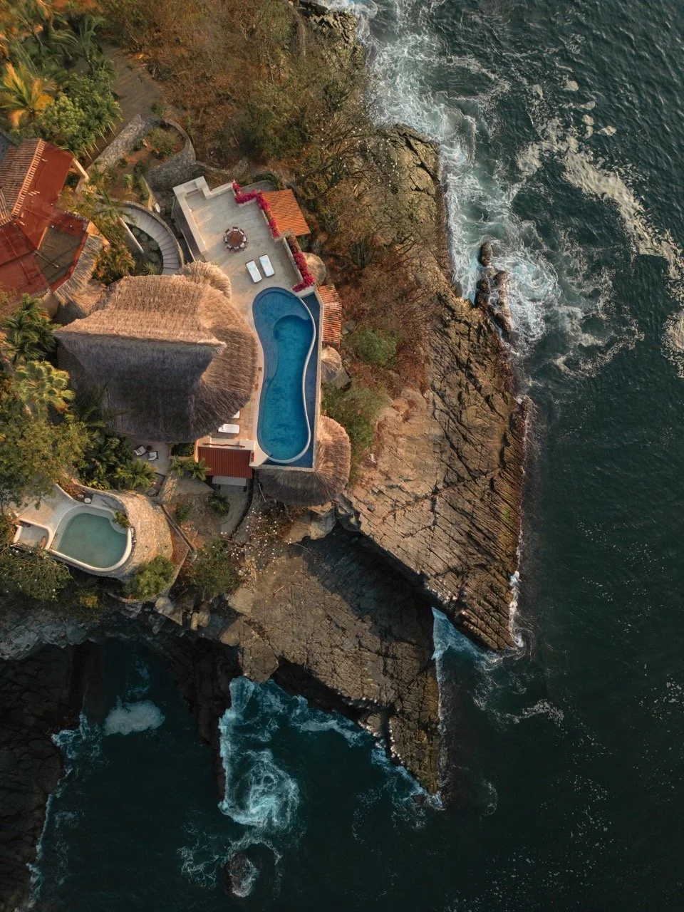 Piscinas en la costa, rodeadas de vegetación y rocas, vista aérea del mar