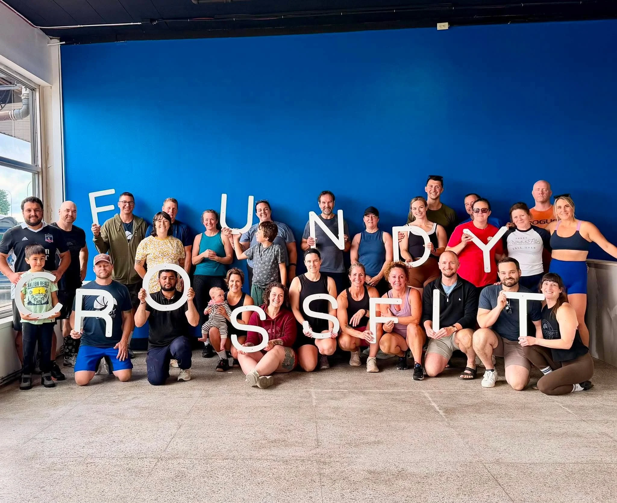 Fundy CrossFit members holding the FUNDY CROSSFIT letters