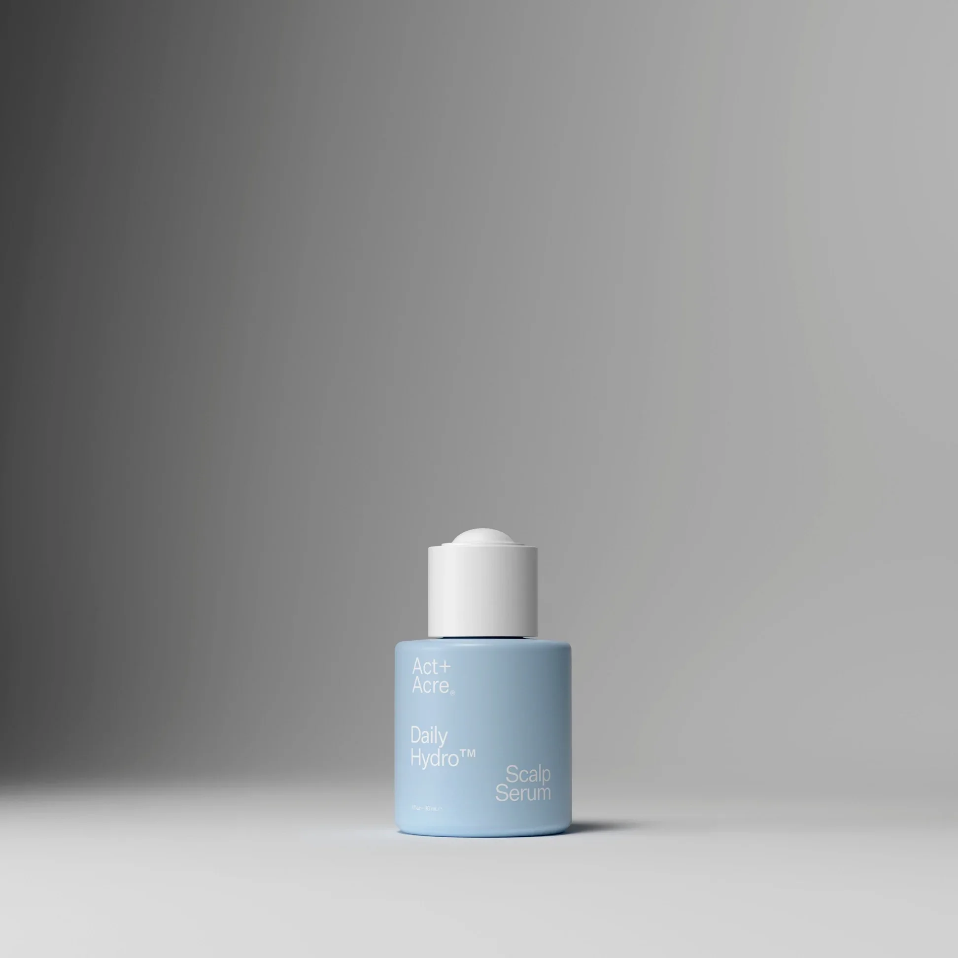 A light blue bottle of skincare product labeled 'Act+ Acre Daily Hydr™ Scalp Serum' stands in front of a plain grey background.