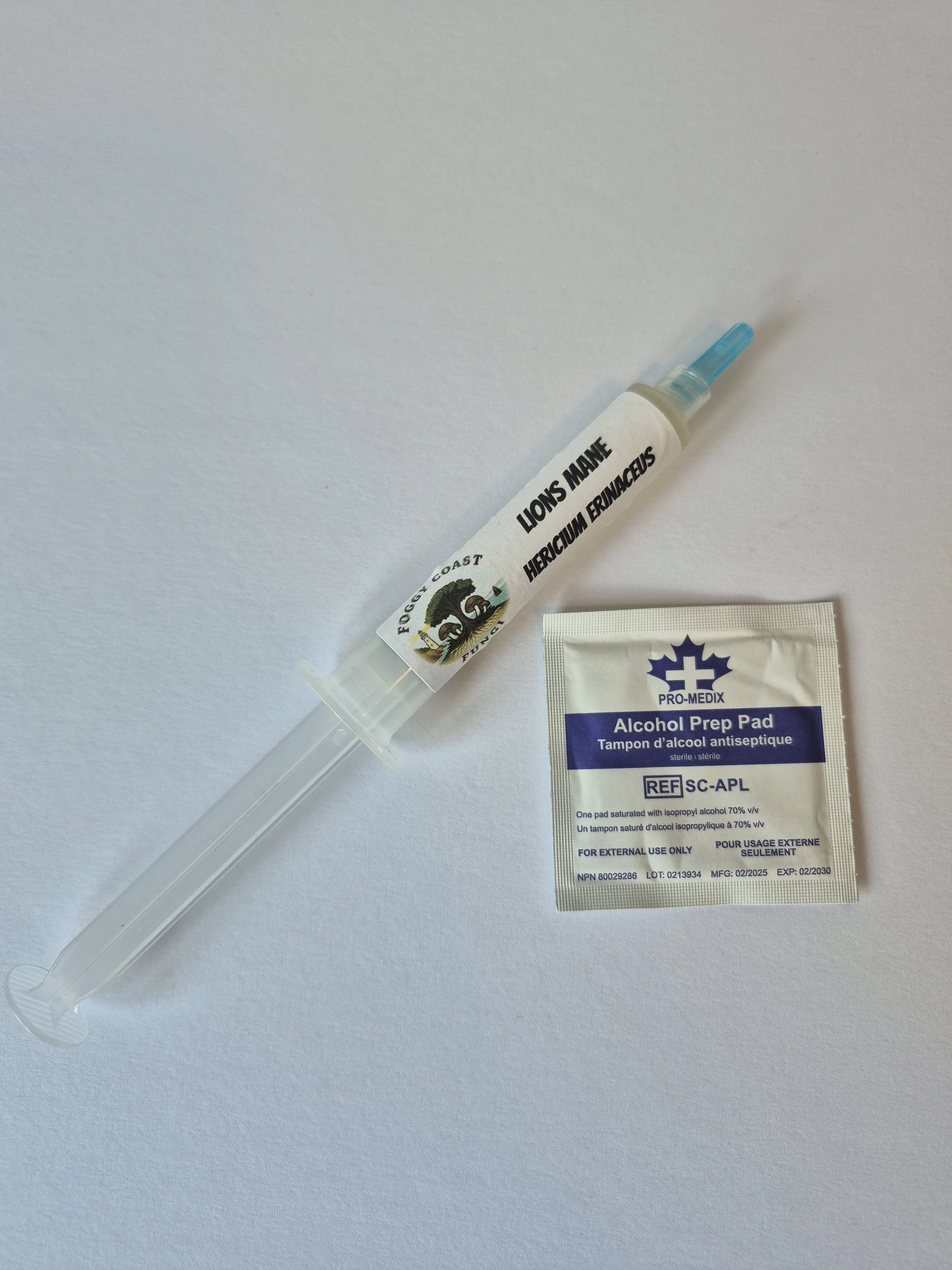 Liquid culture syringe and alcohol prep pad used for sterile mushroom inoculation.