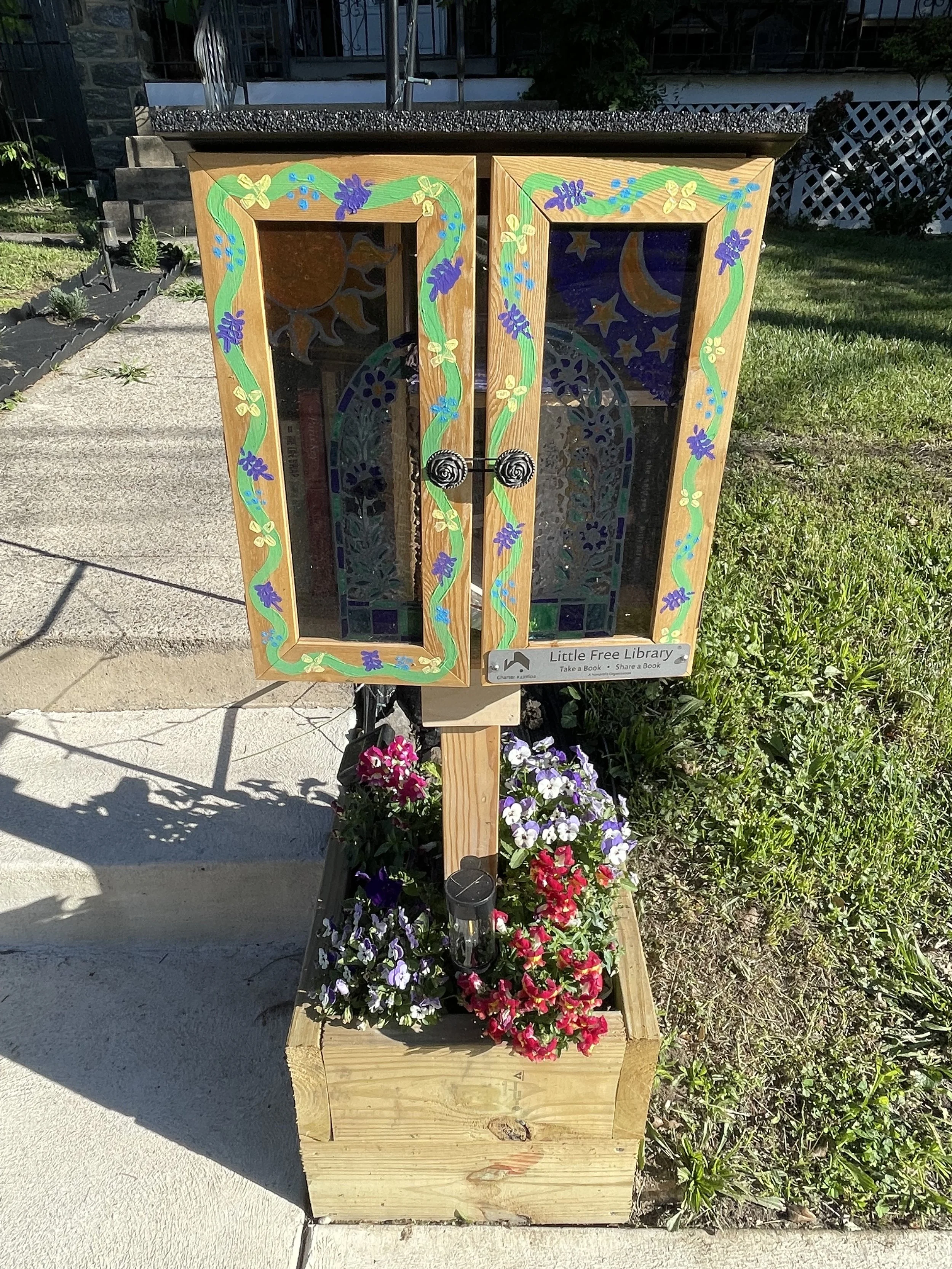 little free library with painted plants on the front