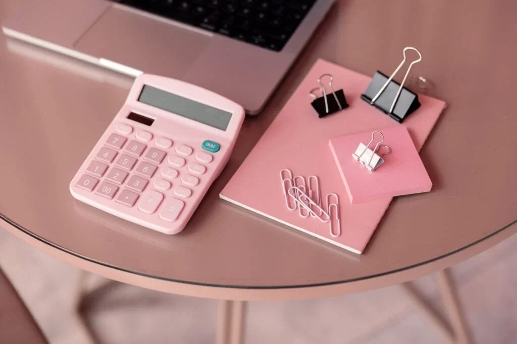 pink-calculator-on-desk-with-notepad-and-clips-1024x683.webp