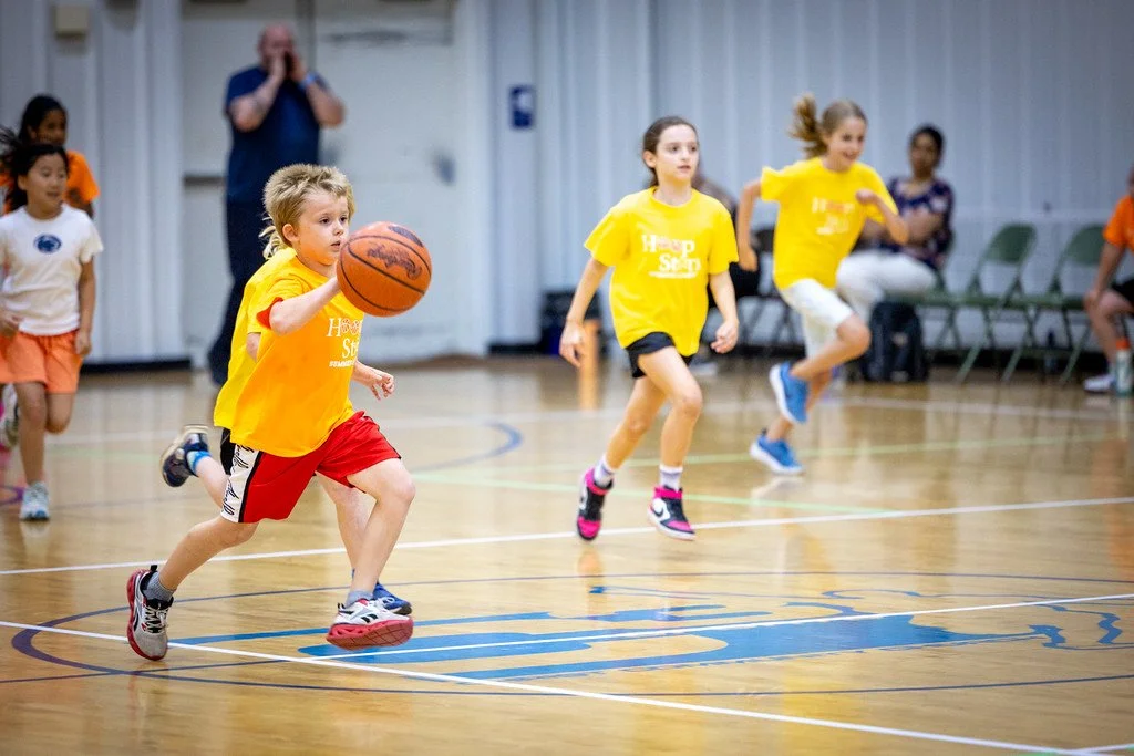 An image of elementary aged students playing in Hoop Stars Summer League in State College, PA