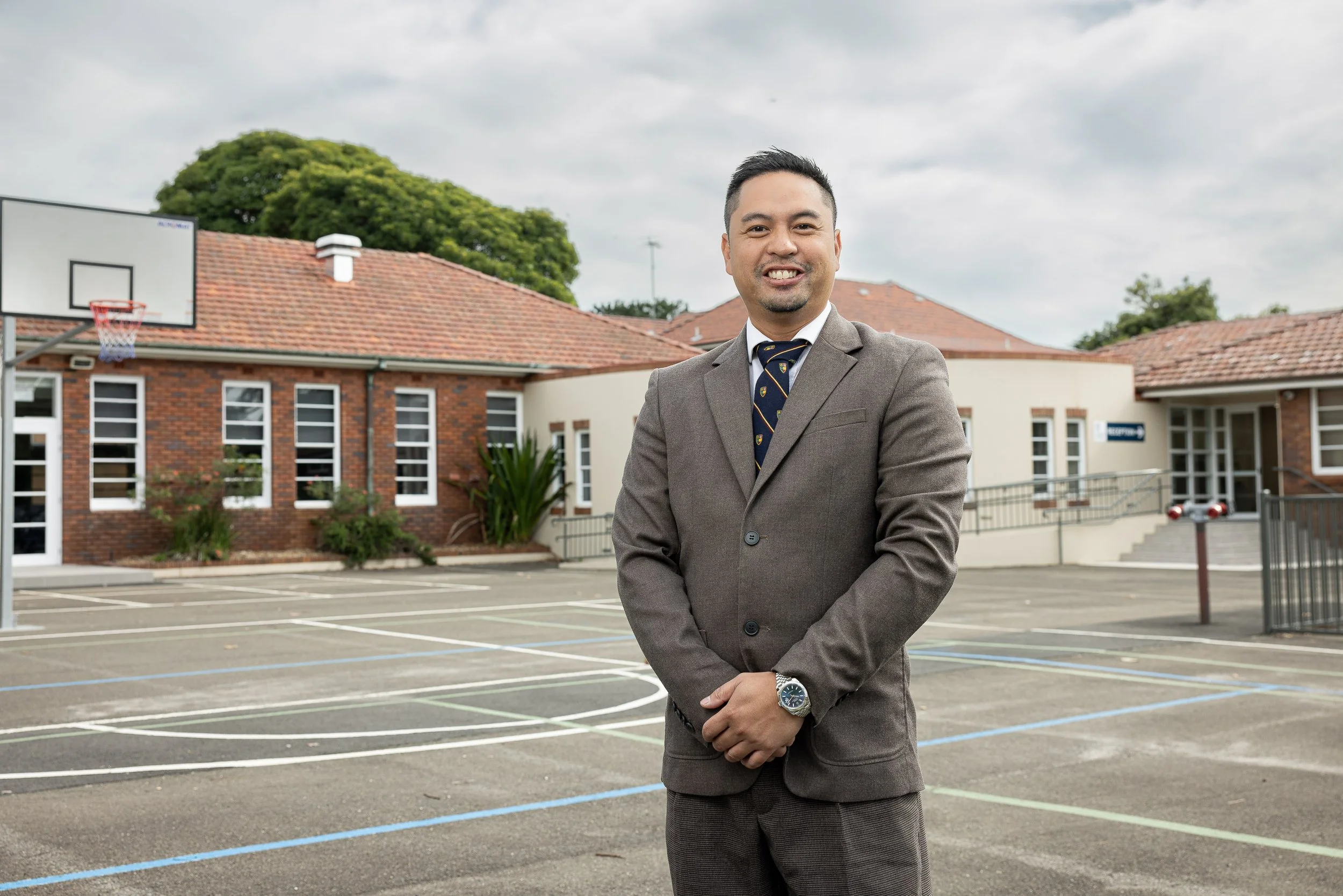 Mr. Ian Mejia, Principal of Hartford College, standing on school campus