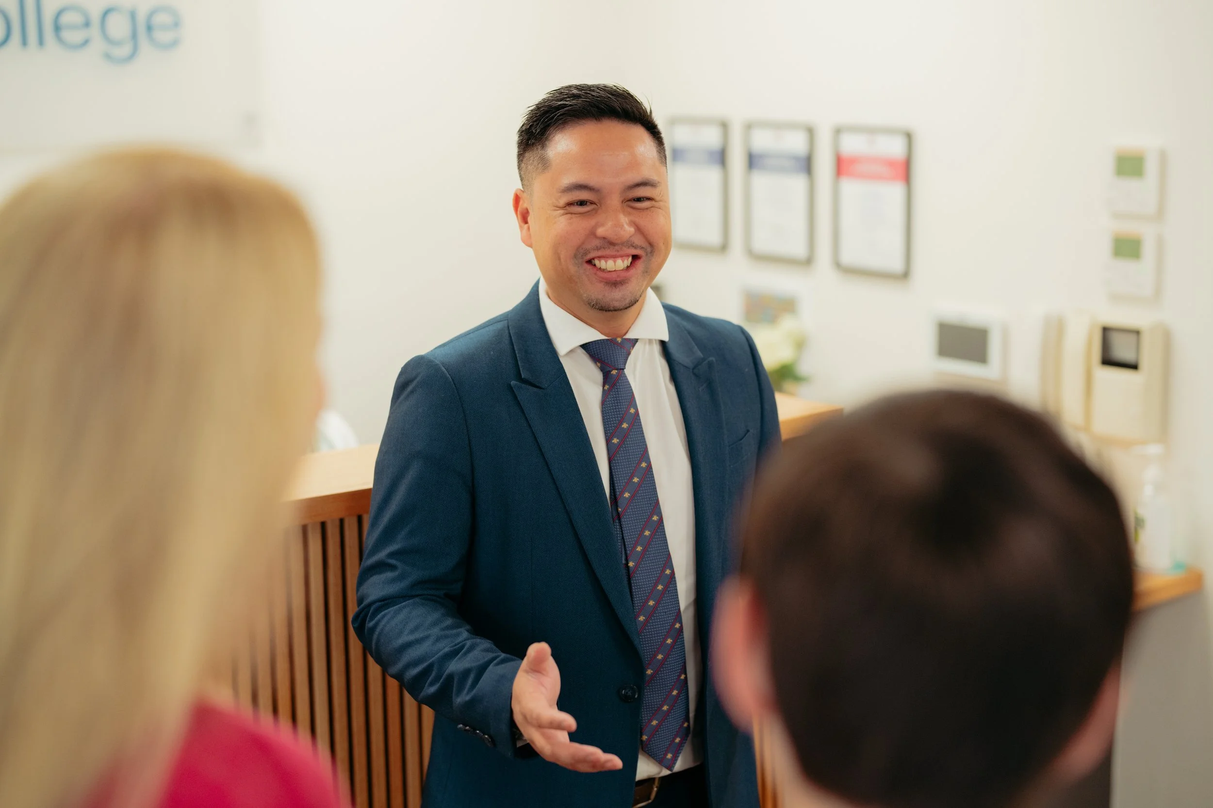 Mr. Ian Mejia, Principal at Hartford College, smiling and speaking to parent and student