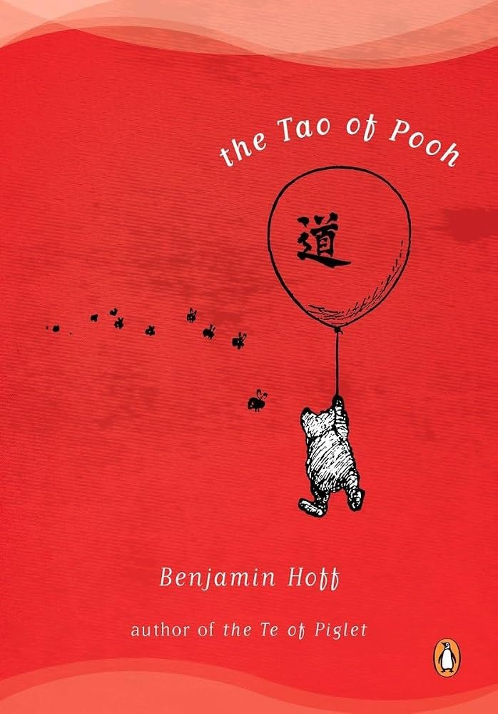 book cover titled 'The Tao of Pooh' by Benjamin Hoff, featuring a drawing of Winnie the Pooh holding onto a balloon with a Chinese character, with a red background.