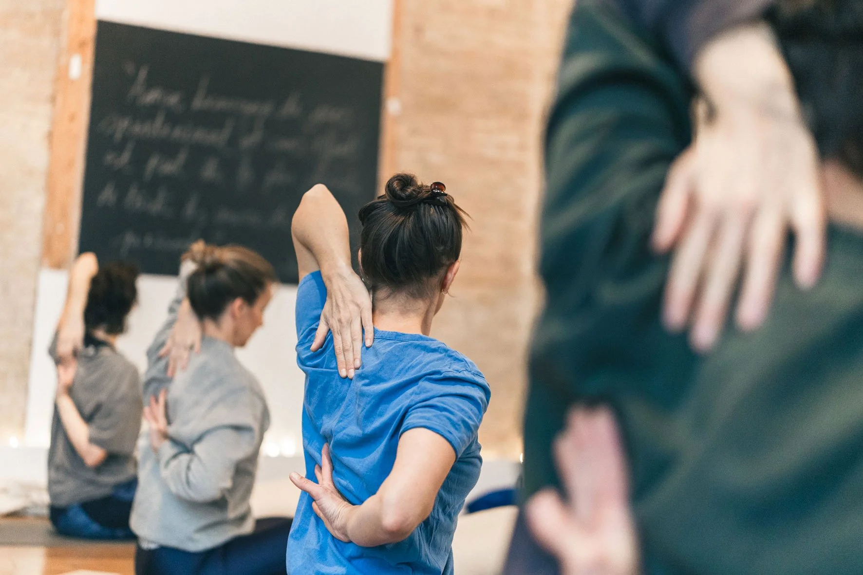Groupe de personnes pratiquant le yoga ou la méditation dans un studio, avec des femmes en position de relaxation ou d'étirement. Happy Shala Studio Yoga Pilates Grenoble