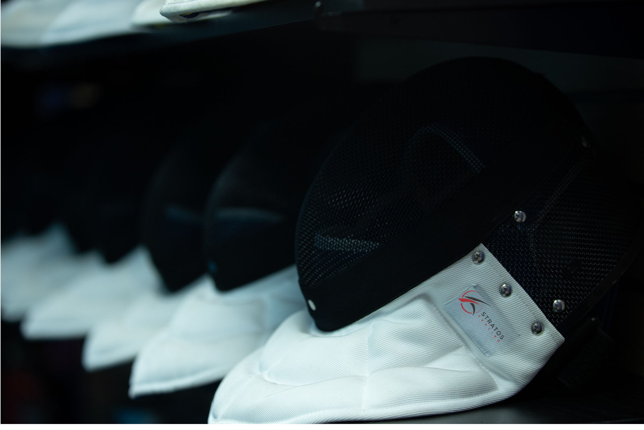 Close-up of a row of epee fencing masks
