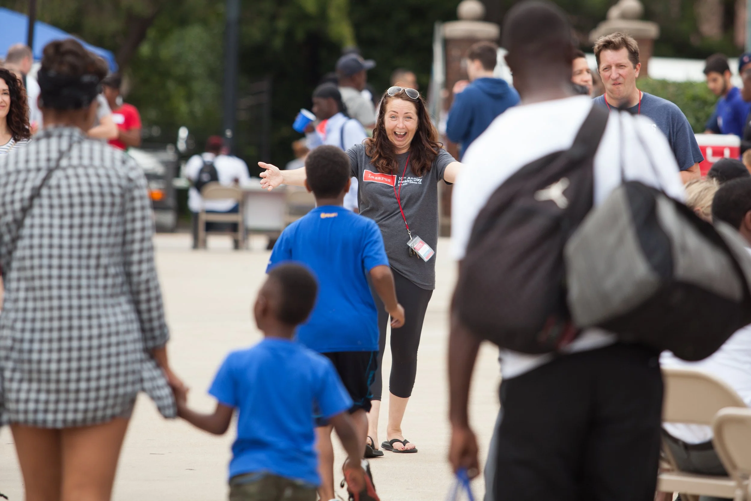 Alli McGill with arms open welcoming a kid.