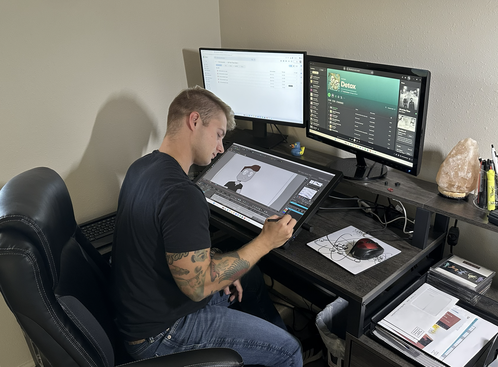 Young man with short blonde hair animating at a desk on an animation tablet.