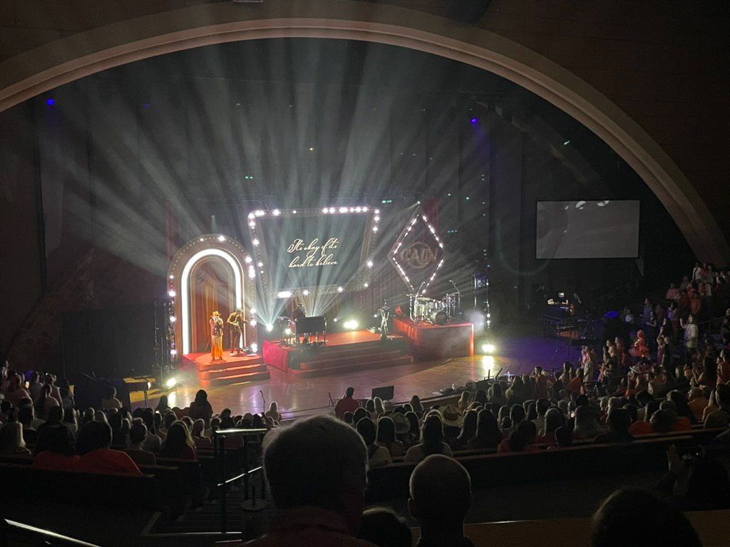 Corporate stage production with theatrical lighting and an audience at Riverbend Centre